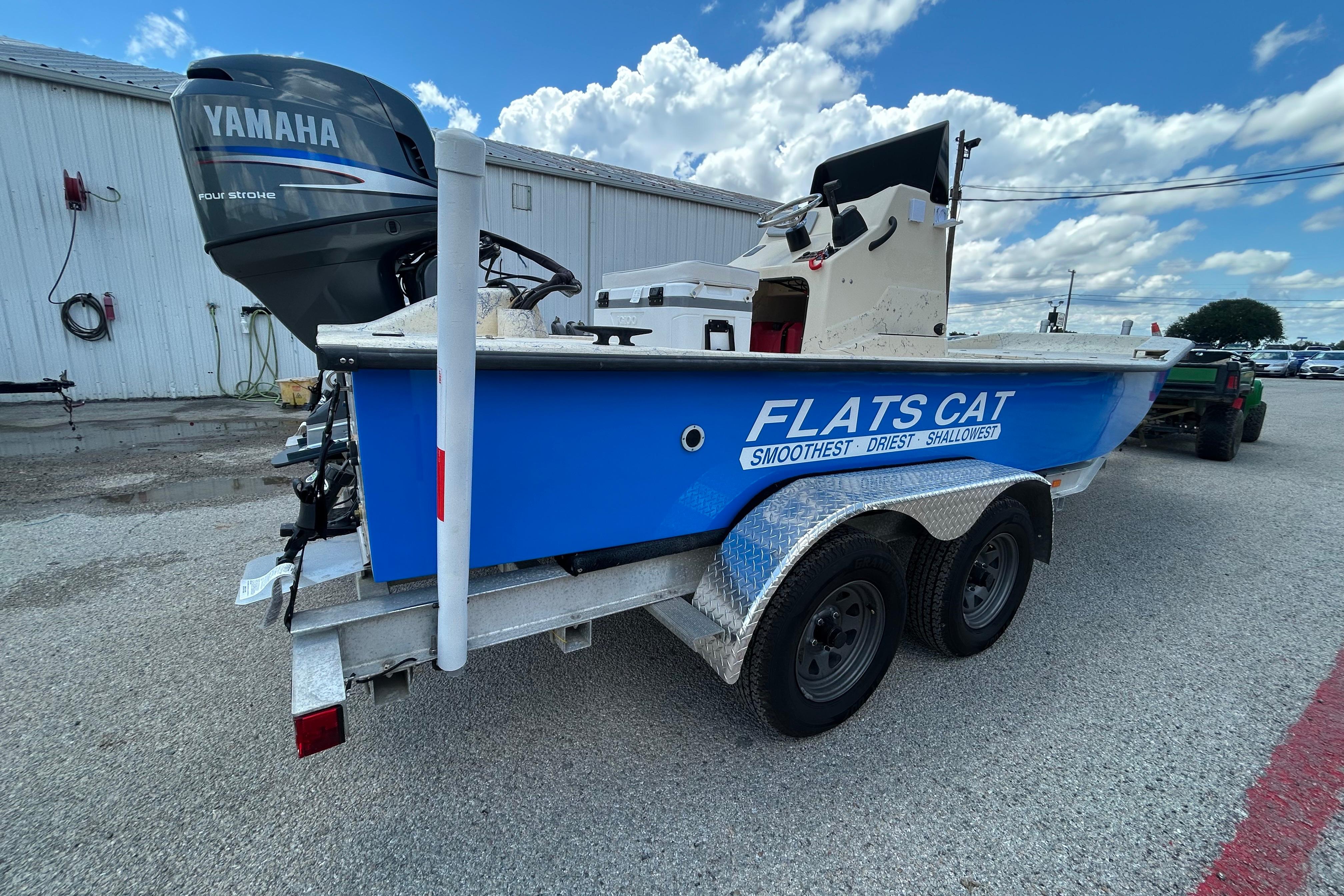 Blue 2007 Flats Cat 19 boat on trailer with Yamaha engine, parked outdoors.