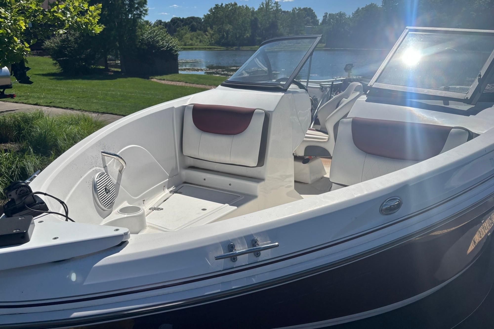 2024 Tahoe 200 S boat with open seating, docked by a scenic lake.