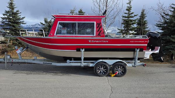 2024 Spartan 220 Maximus boat on trailer, red and black design, parked outdoors.