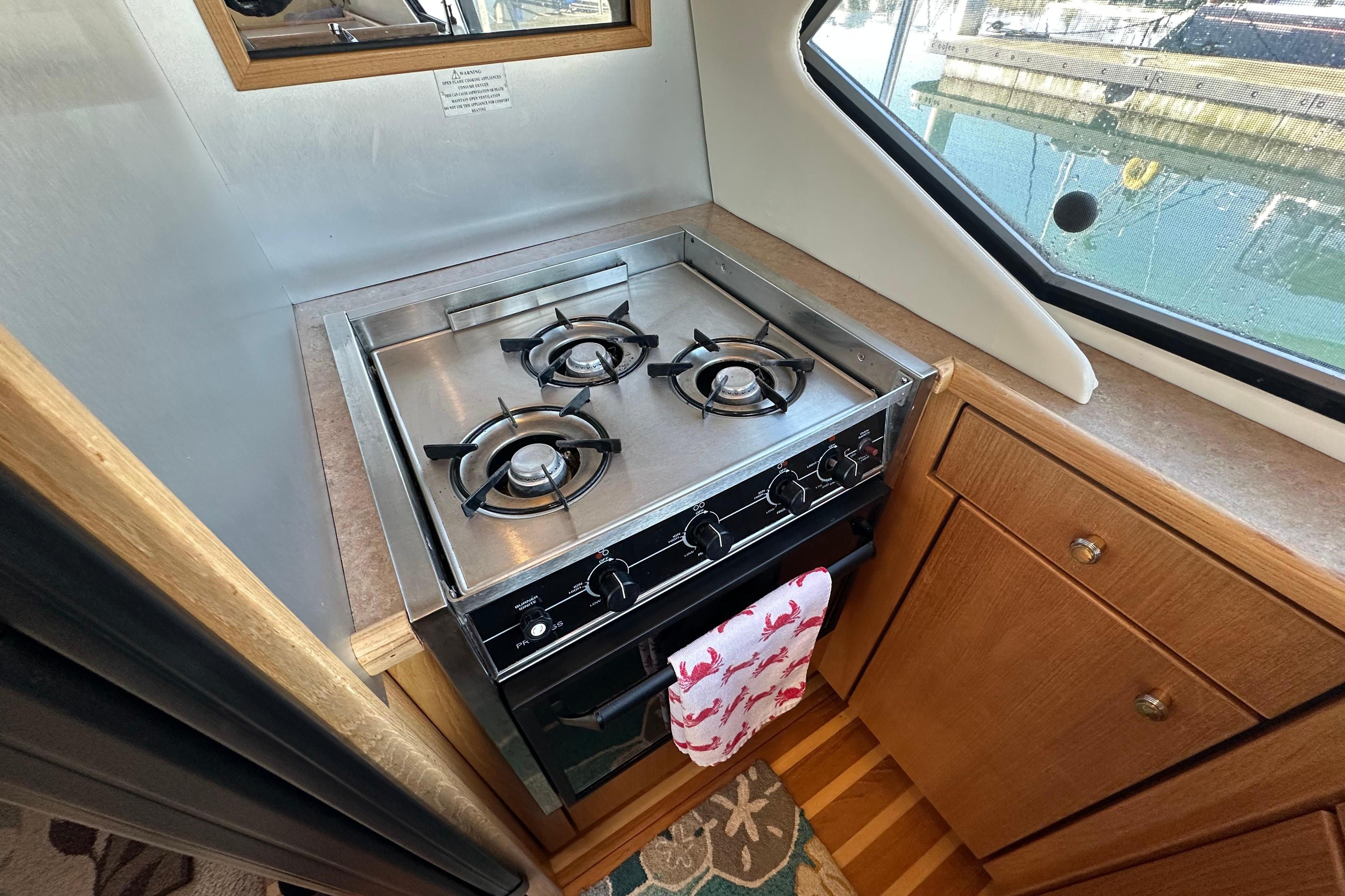 Compact kitchen area in a 2000 Bayliner 4087 Aft Cabin Motoryacht with a three-burner stove.