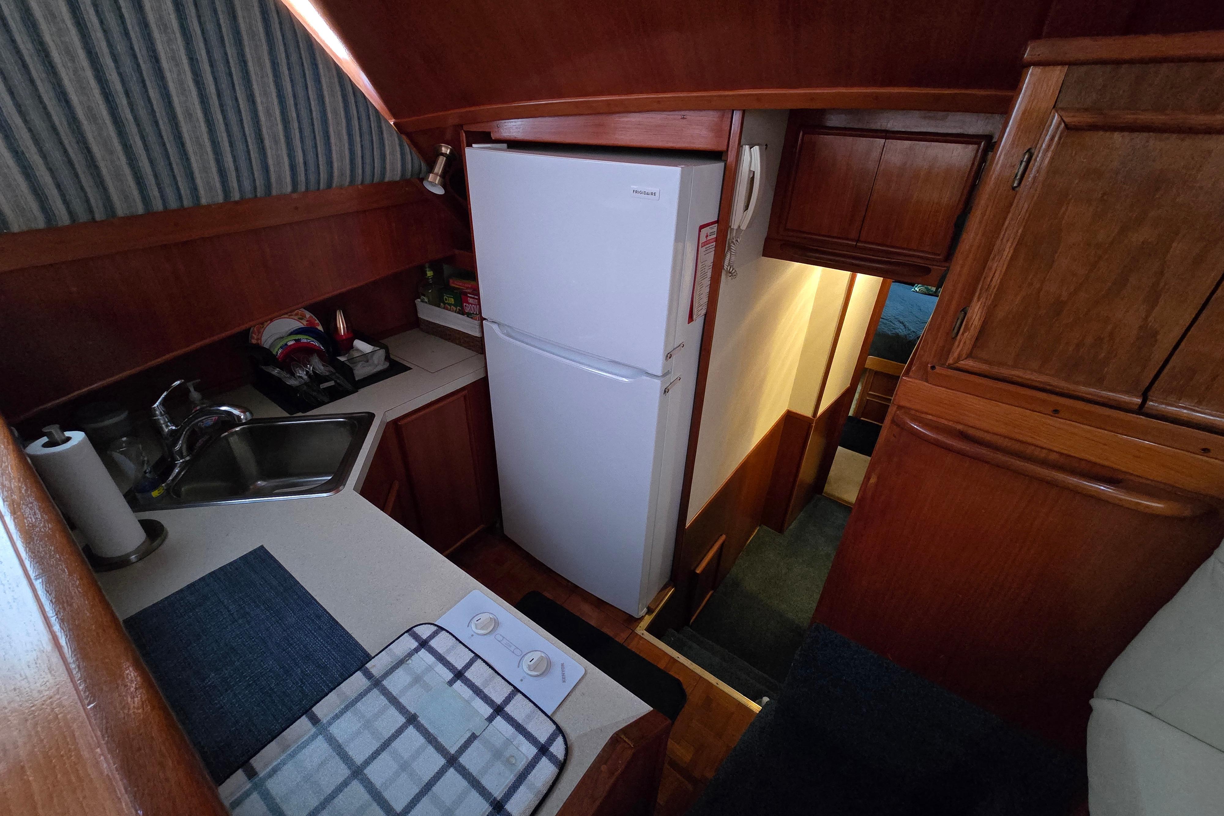 1988 Post 46 Convertible yacht interior with kitchenette, featuring wood cabinetry and modern appliances.