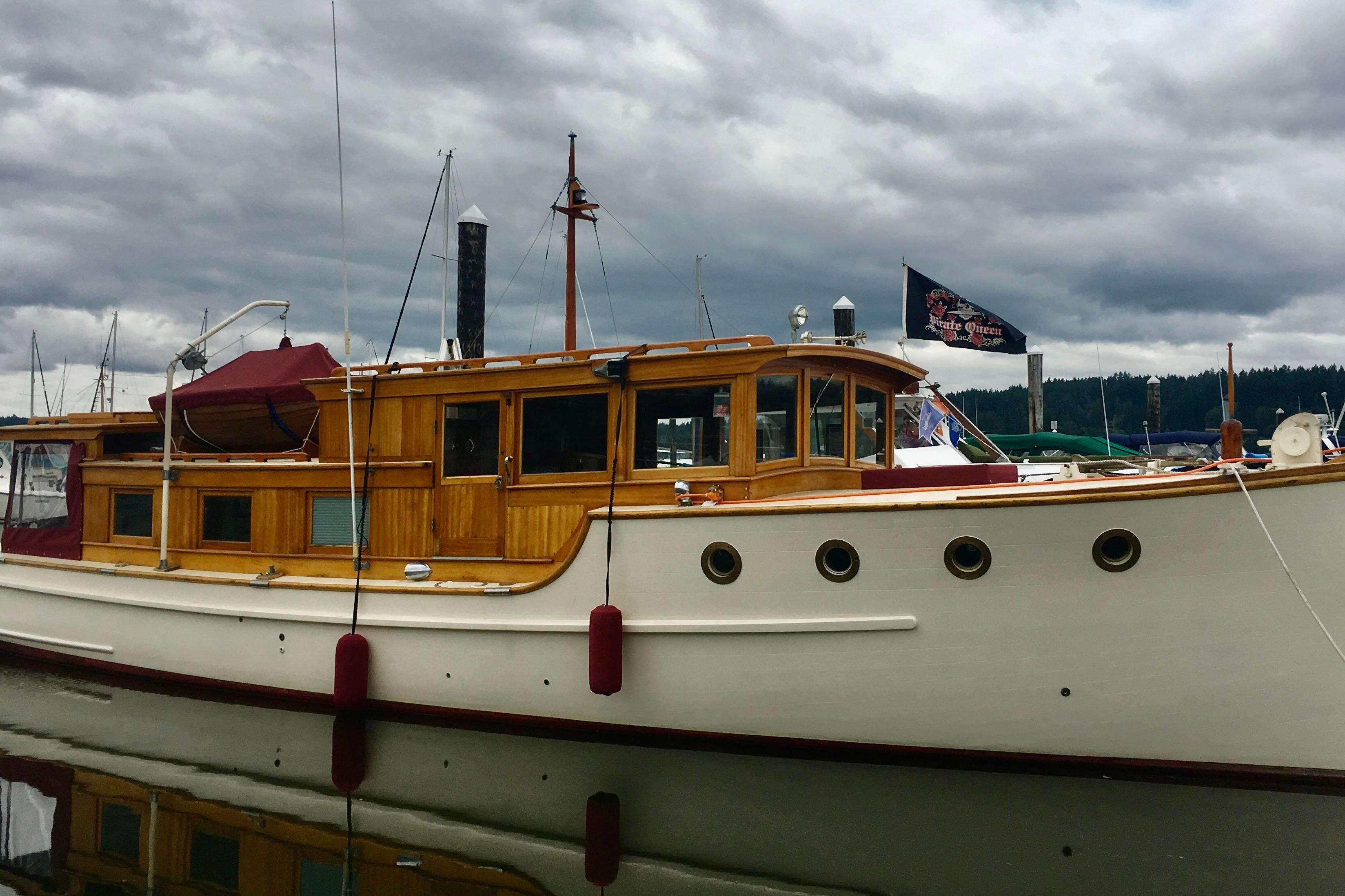 Vintage 1942 Grenfell 42 Custom boat with wooden cabin, docked under cloudy skies.
