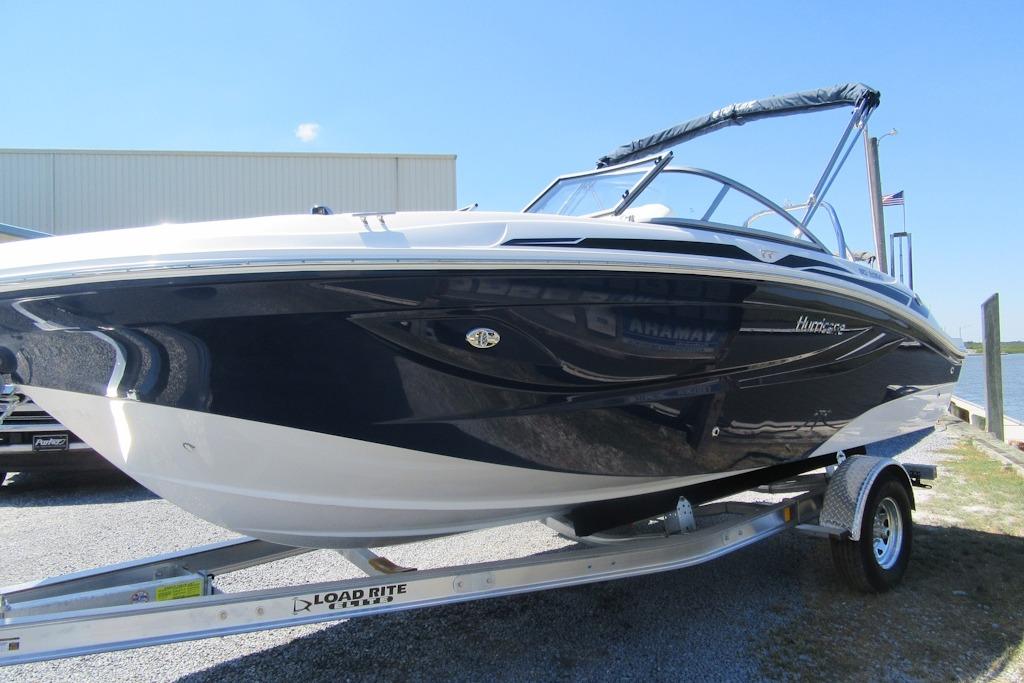 2027 Hurricane SunDeck 2050 OB boat on trailer, sleek design, parked outdoors.