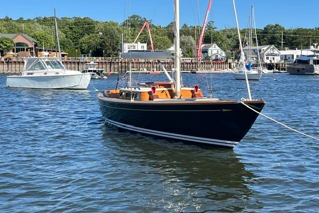 Sailboat on calm water, Morris 36 model, 2006, with scenic harbor background.