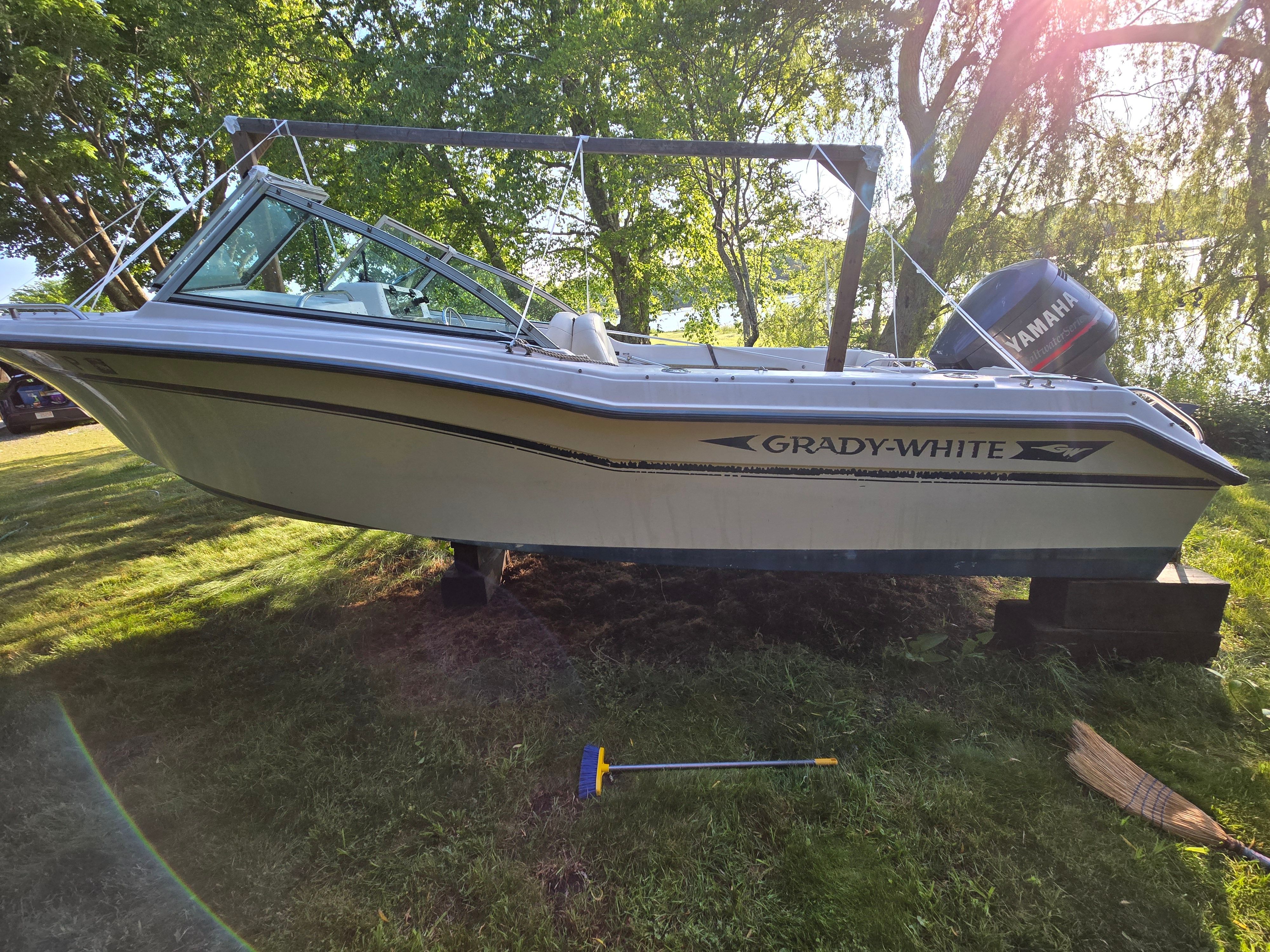 A 1994 Grady-White Tournament 192 boat is on grass, surrounded by trees.