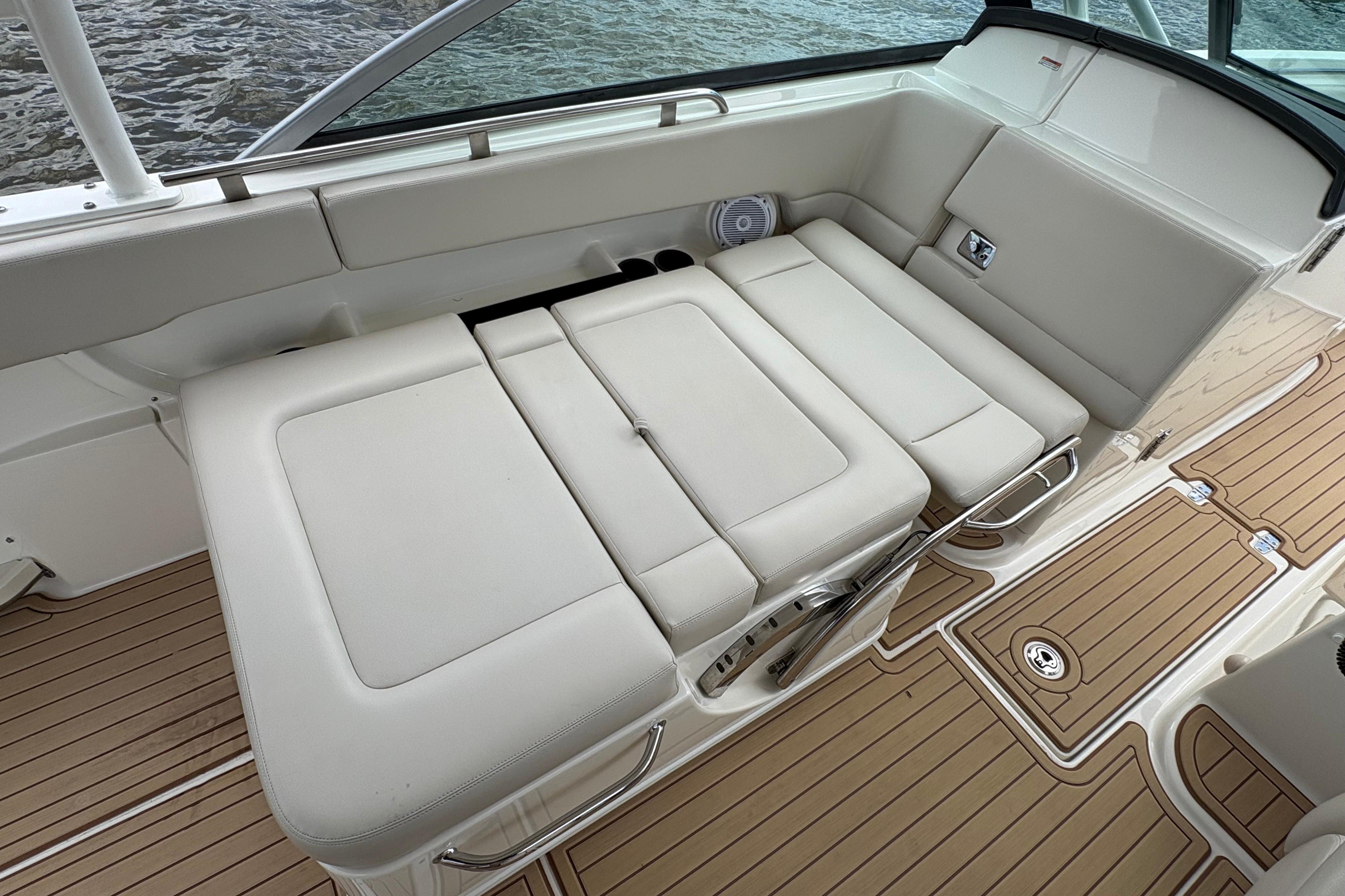 2017 Boston Whaler 270 Vantage boat interior with beige seating and wooden like SeaDeck flooring.
