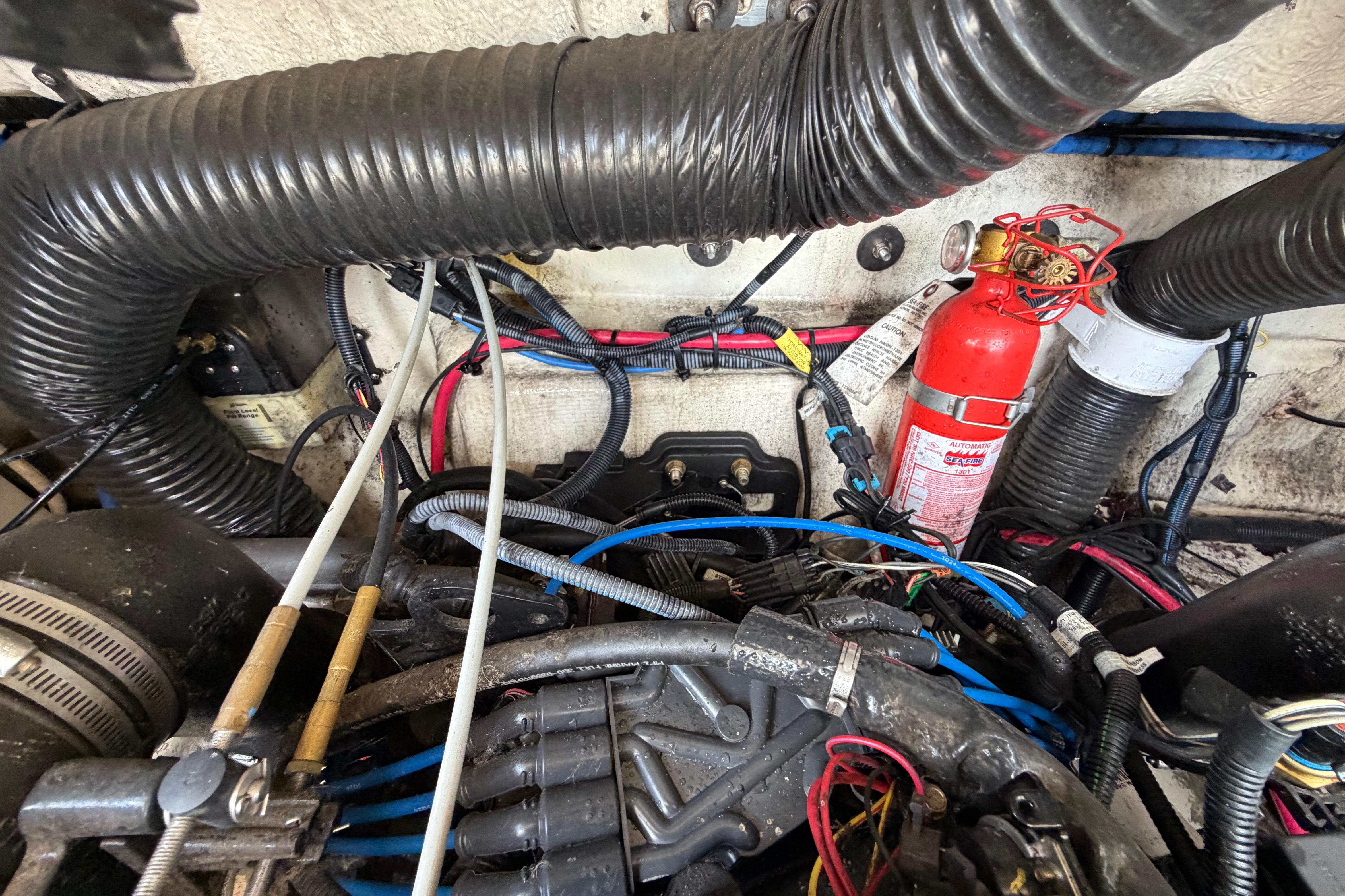 Engine compartment of a 2004 Sea Ray 240 Sundeck with visible wiring and fire extinguisher.