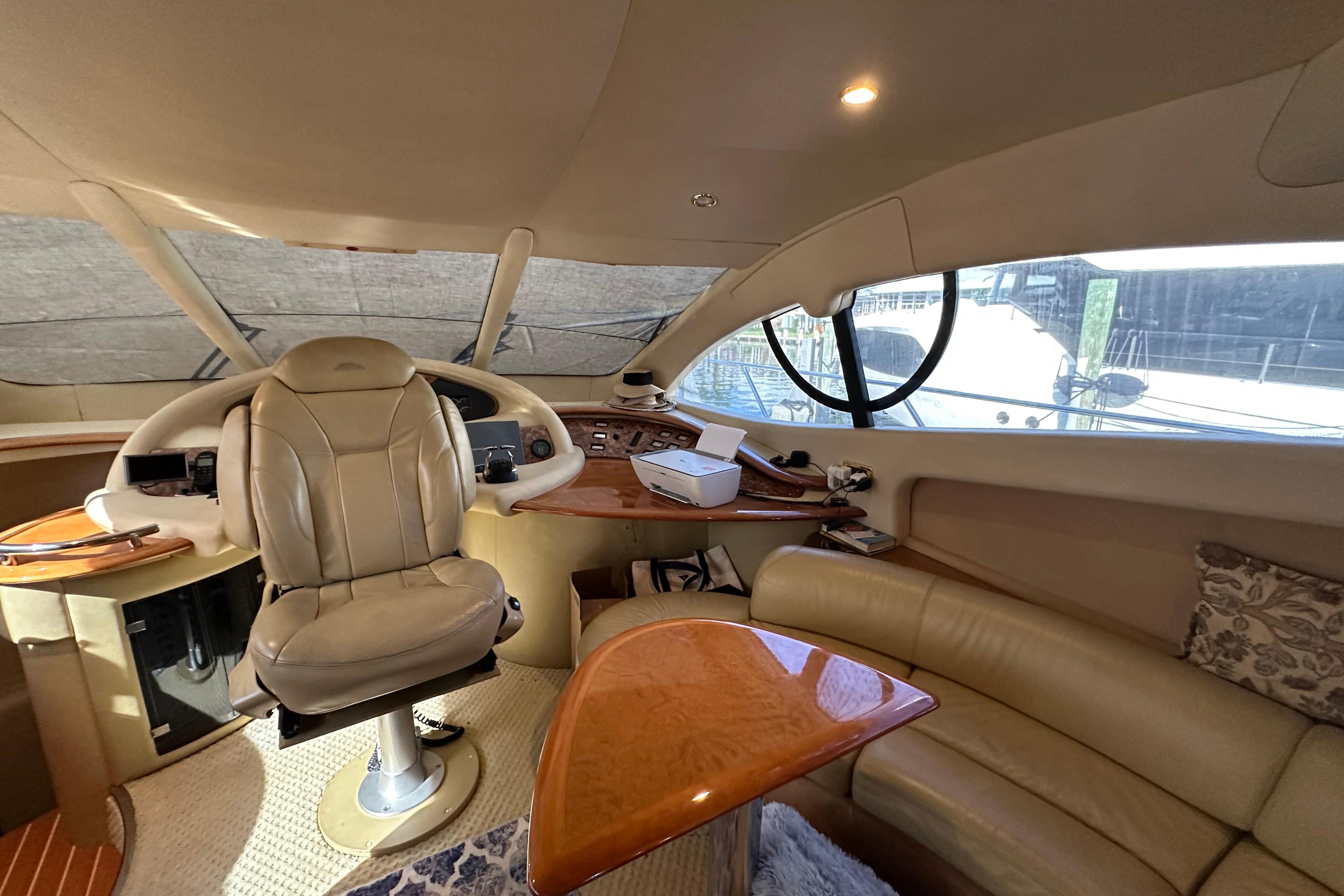 Luxurious interior of a 2004 Azimut 55E yacht with leather seating and wooden accents.