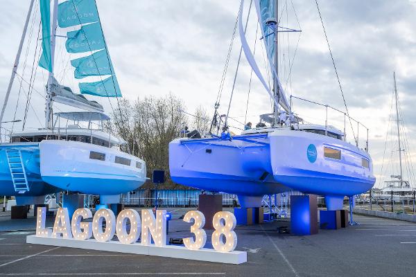 2025 Lagoon 38 catamarans displayed outdoors with illuminated sign.