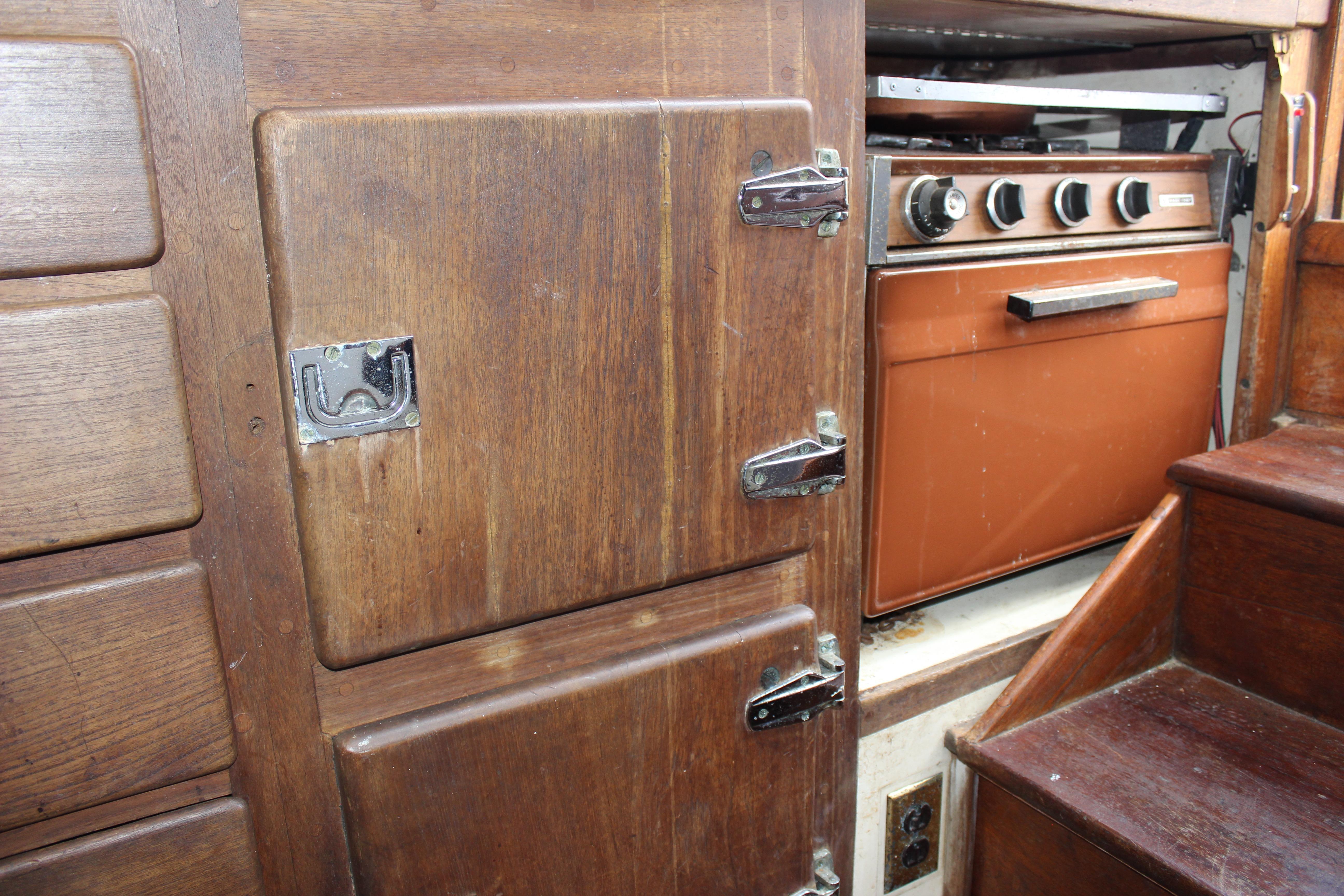 Wooden interior of 1966 Gardner 37 Ketch with vintage stove and cabinetry.