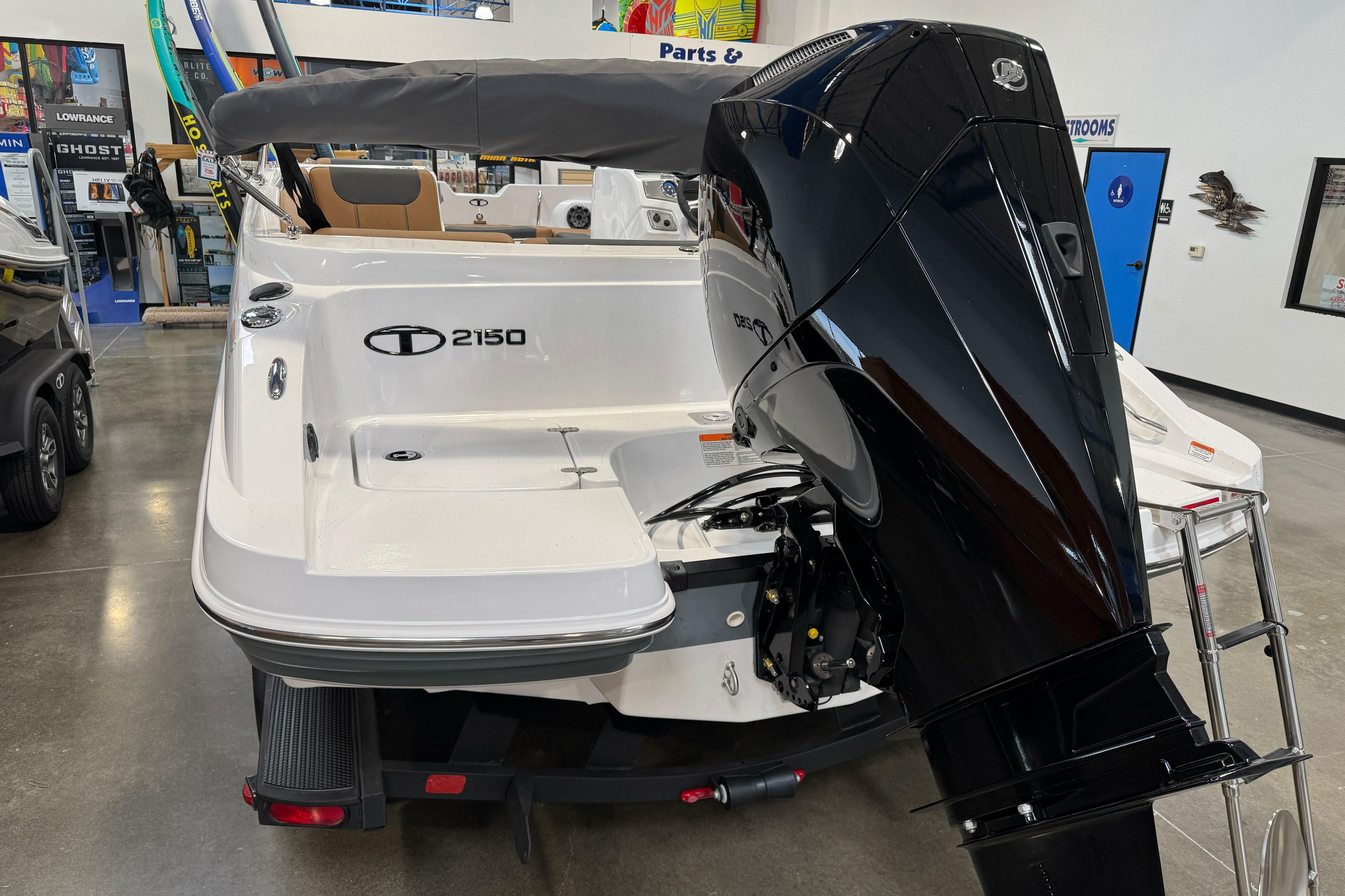 2026 Tahoe 2150 boat with powerful outboard motor in showroom setting.