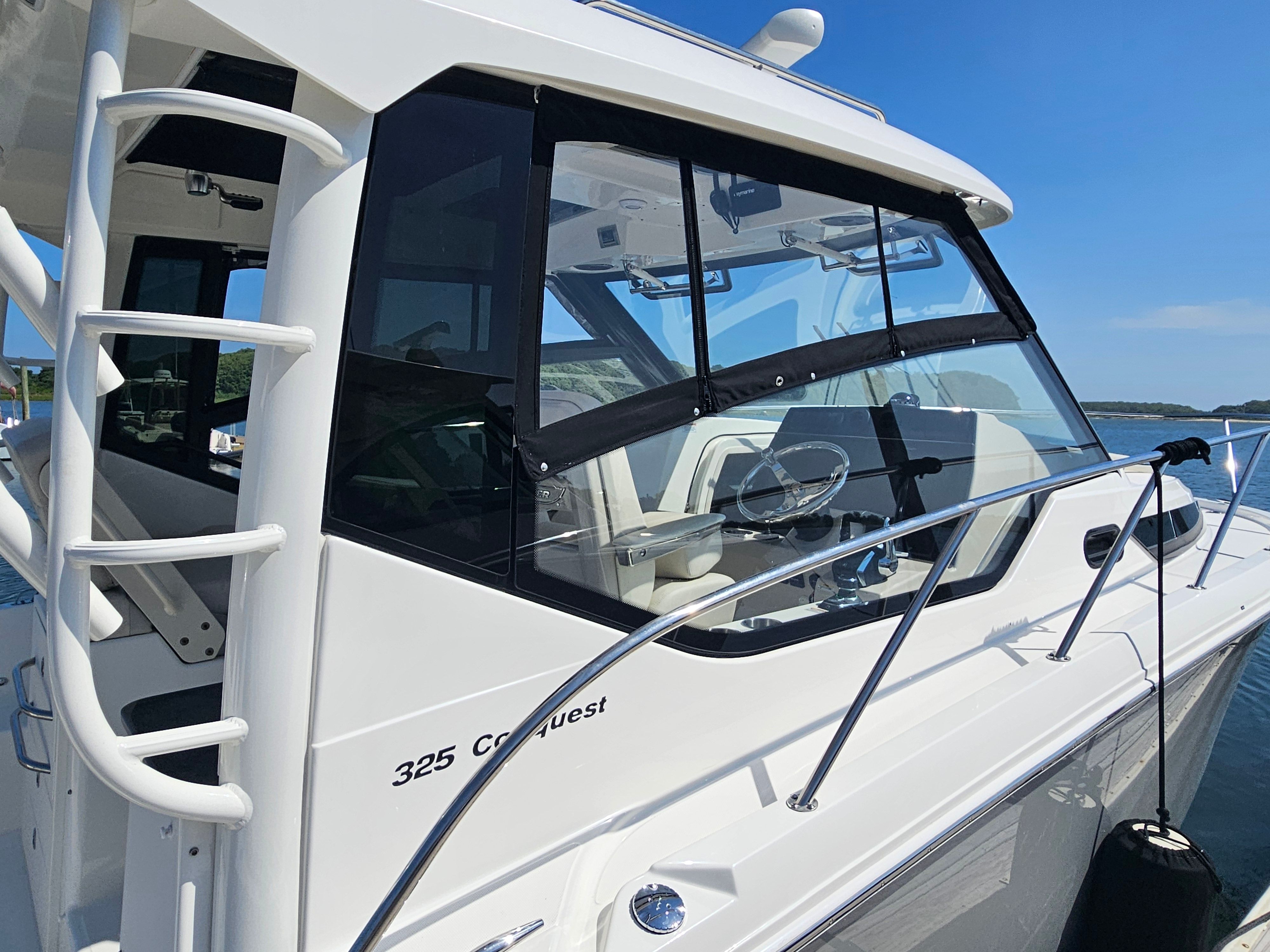 The 2023 Boston Whaler 325 Conquest is docked. It features a sleek design and large windows.