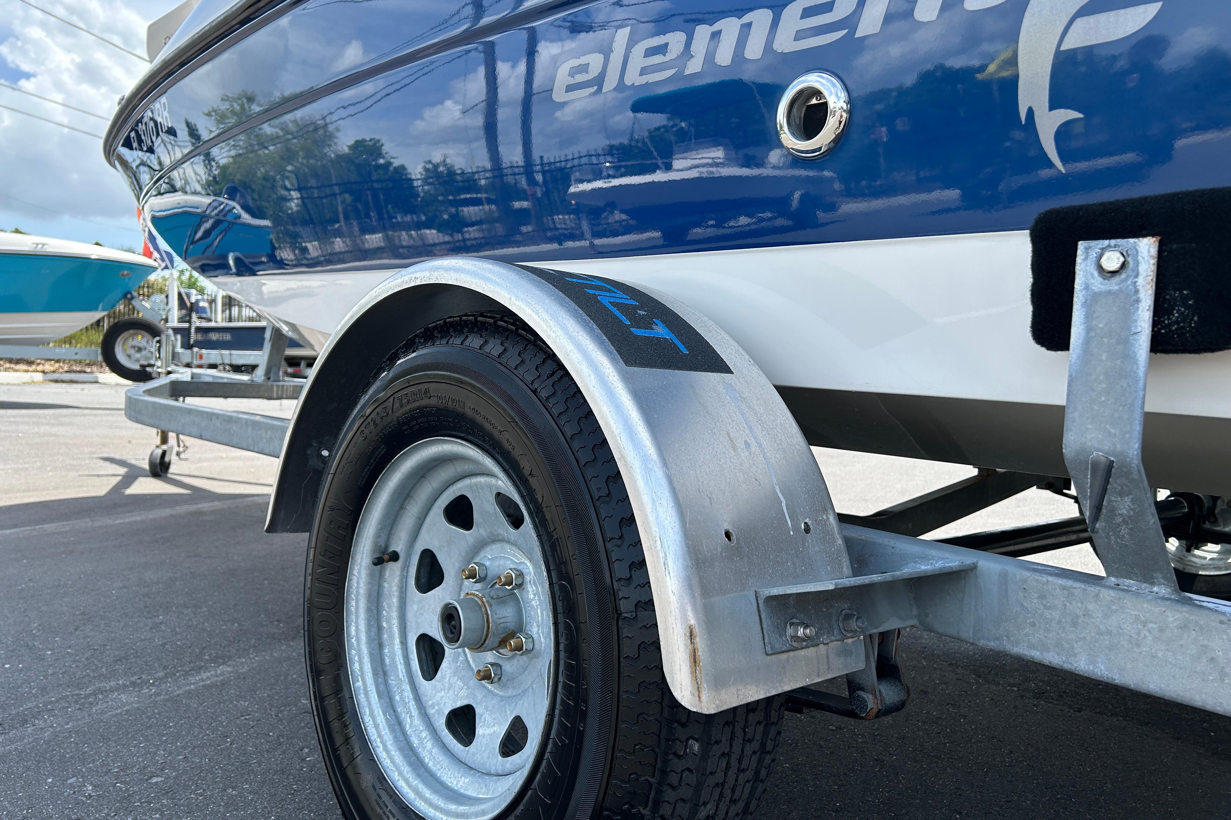 2018 Bayliner Element F16 boat on trailer, close-up of wheel and hull.