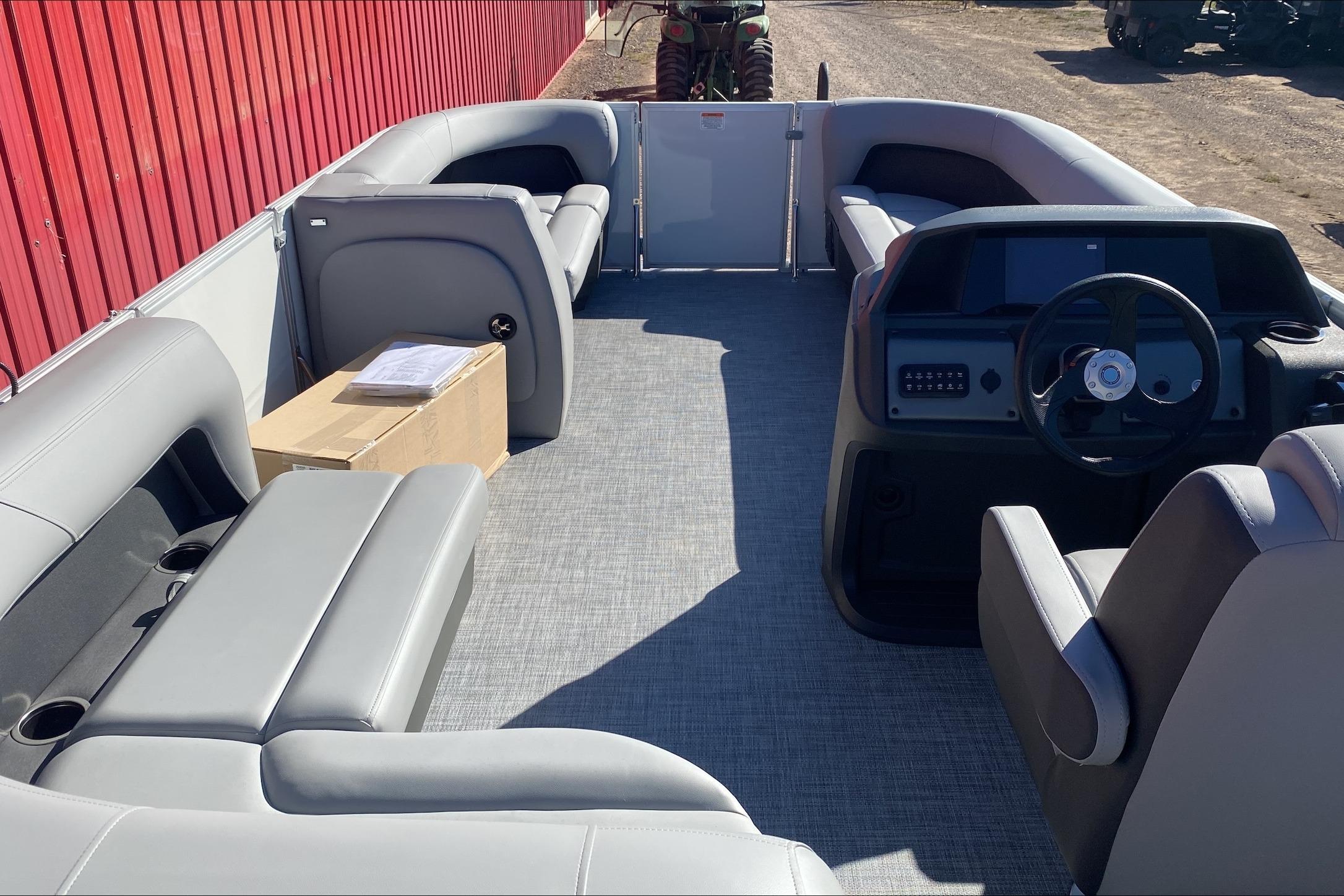 2026 Sun Tracker Party Barge 18 DLX interior with gray seating and steering console.