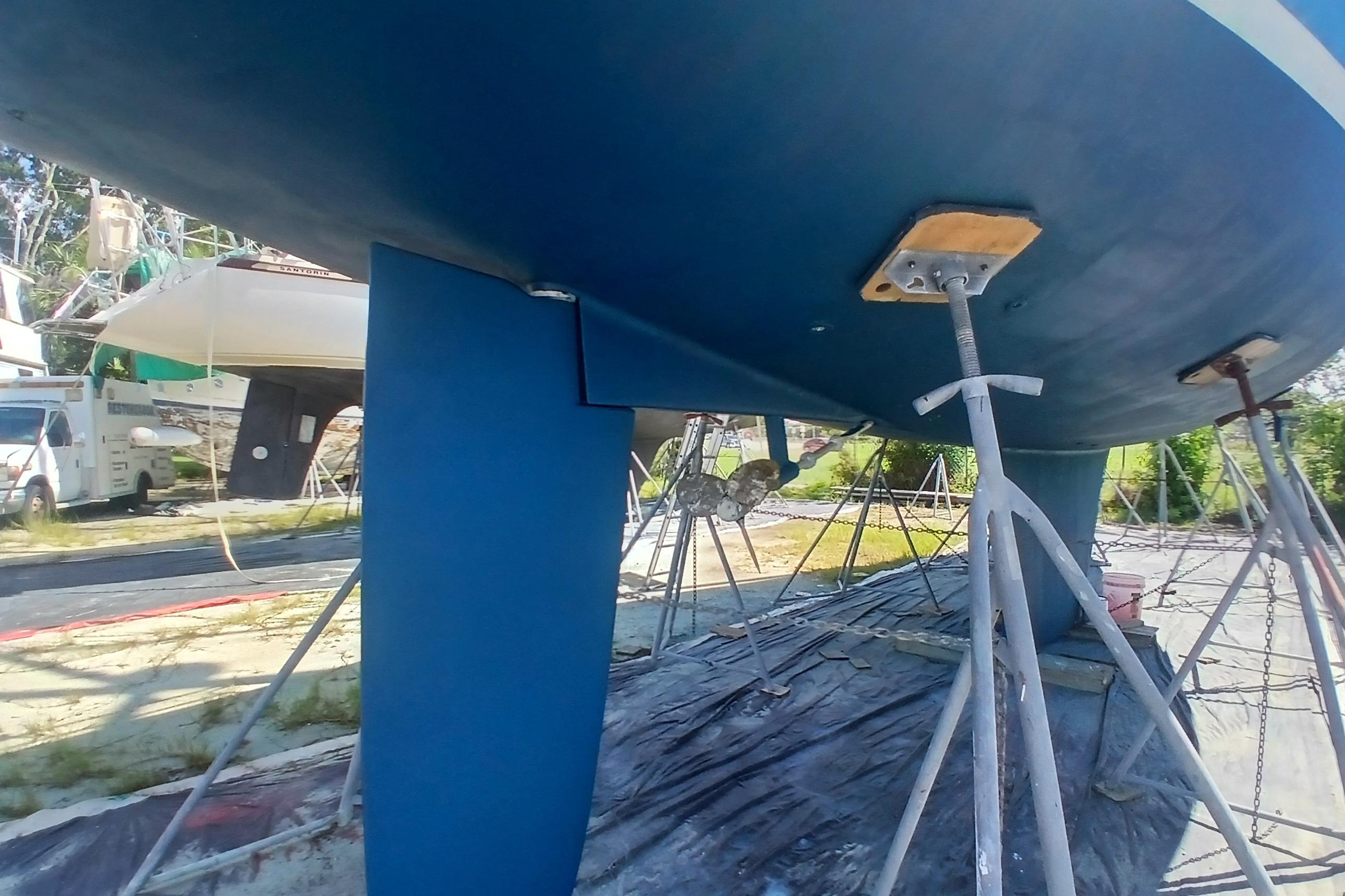 1995 Catalina 42 MkII sailboat on stands, showing keel and hull in a boatyard.