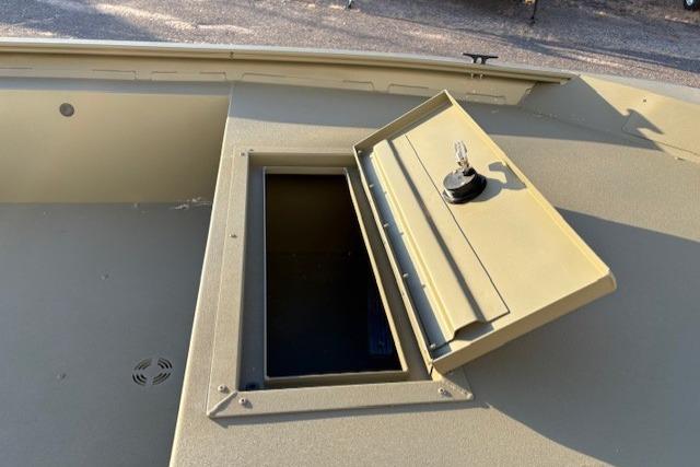 2026 Tracker Grizzly 1754 Utility boat storage compartment with open hatch and key.