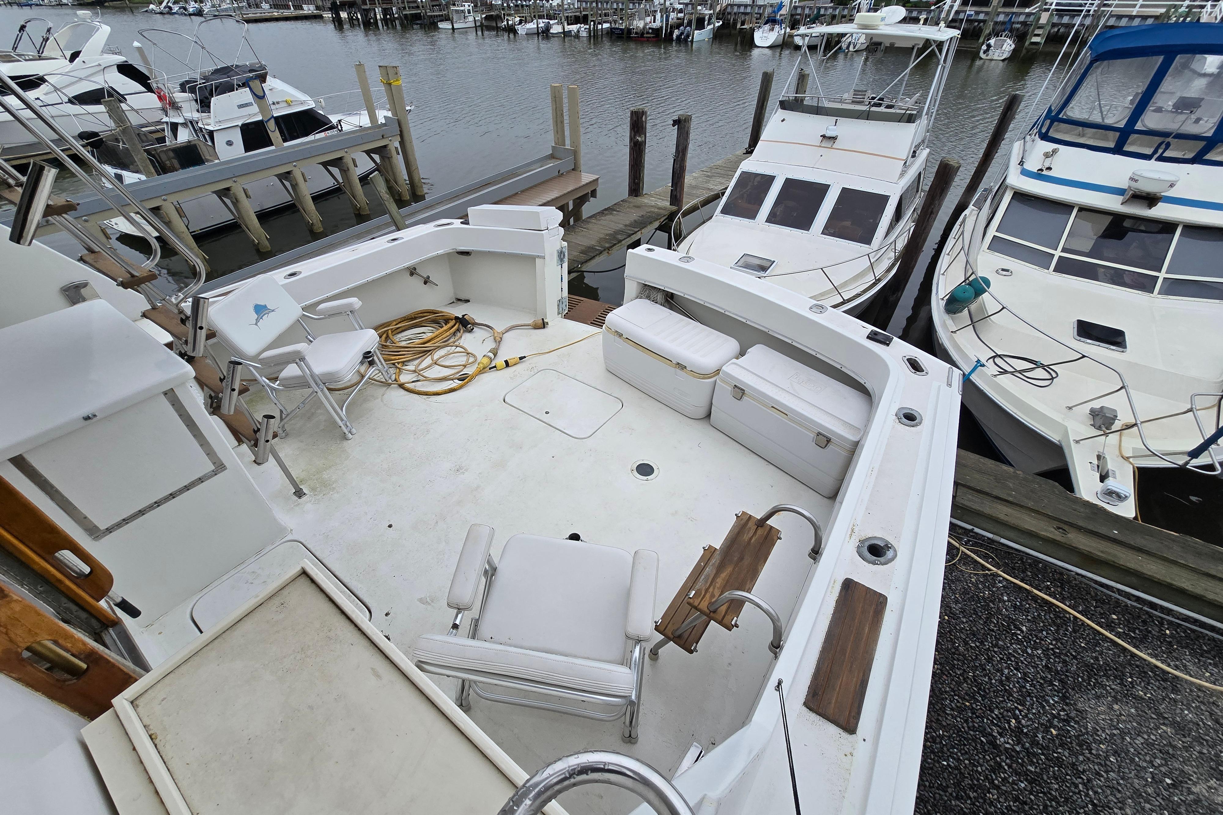 1975 Hatteras 46 Convertible boat docked at marina, featuring spacious deck area.