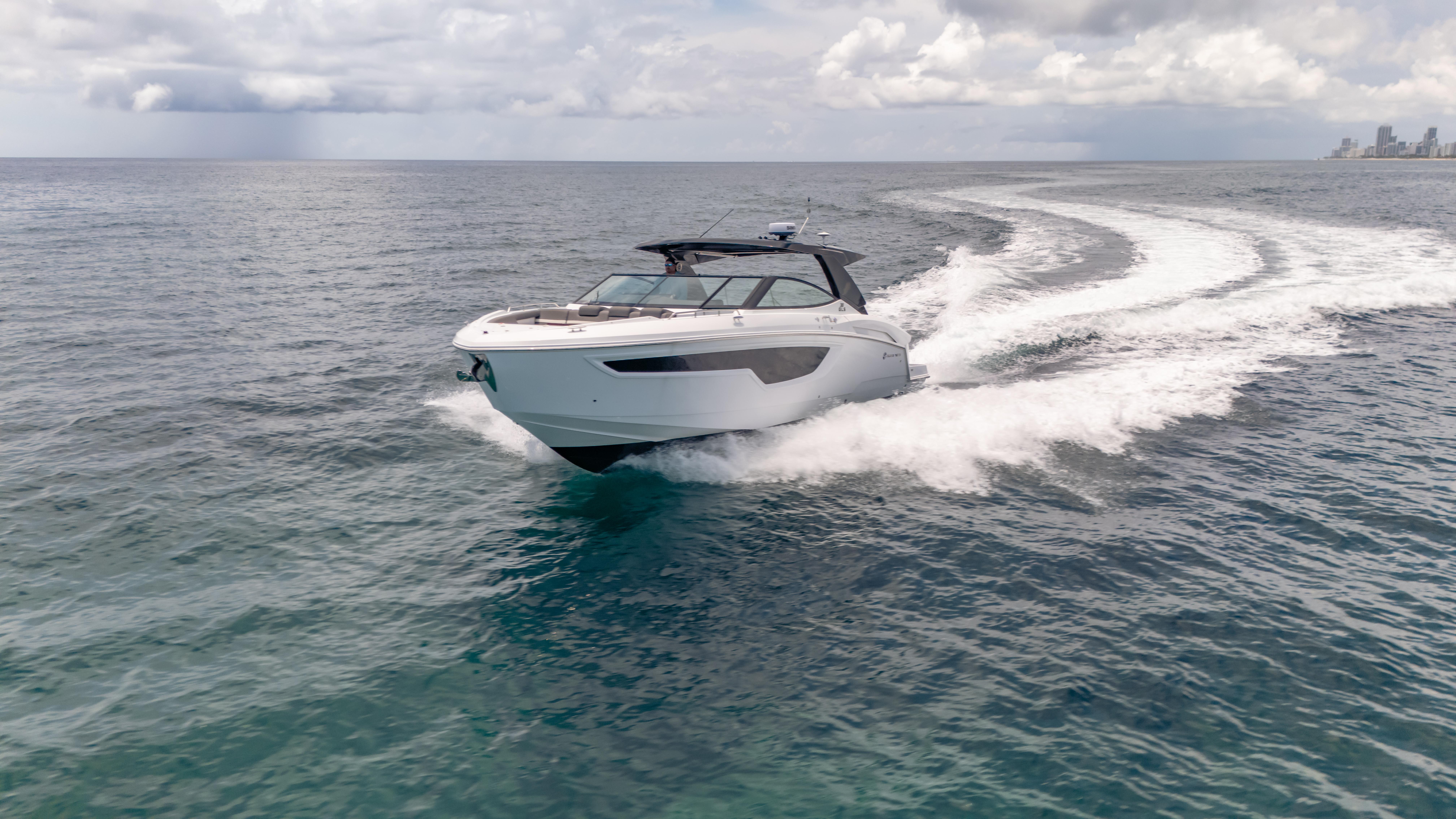 2021 Cruisers Yachts 38 GLS speeding on open water under cloudy skies.