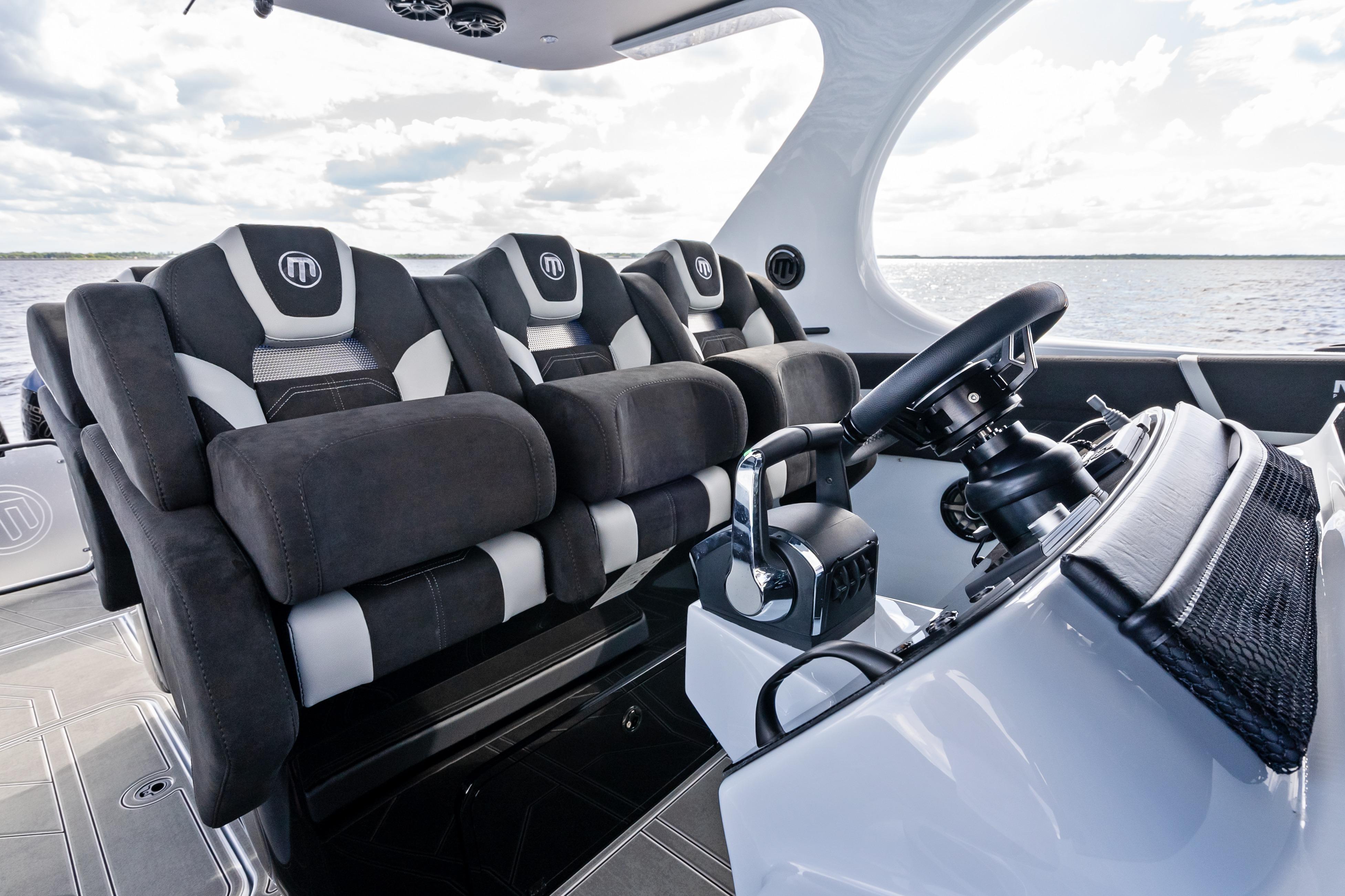Luxurious interior of 2027 Mystic Powerboats M4200, featuring plush seating and advanced steering controls.