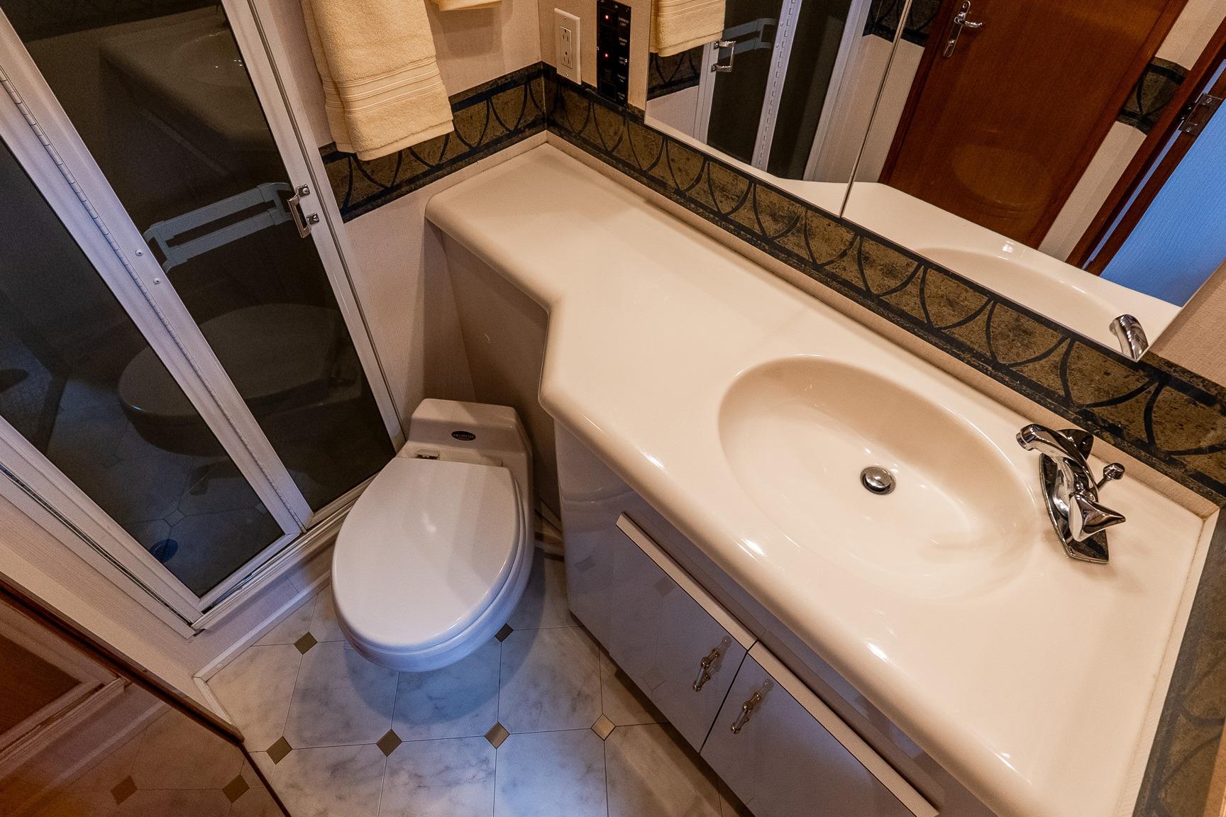 Bathroom interior of 2000 Viking 50' Convertible yacht, featuring sink, toilet, and shower.