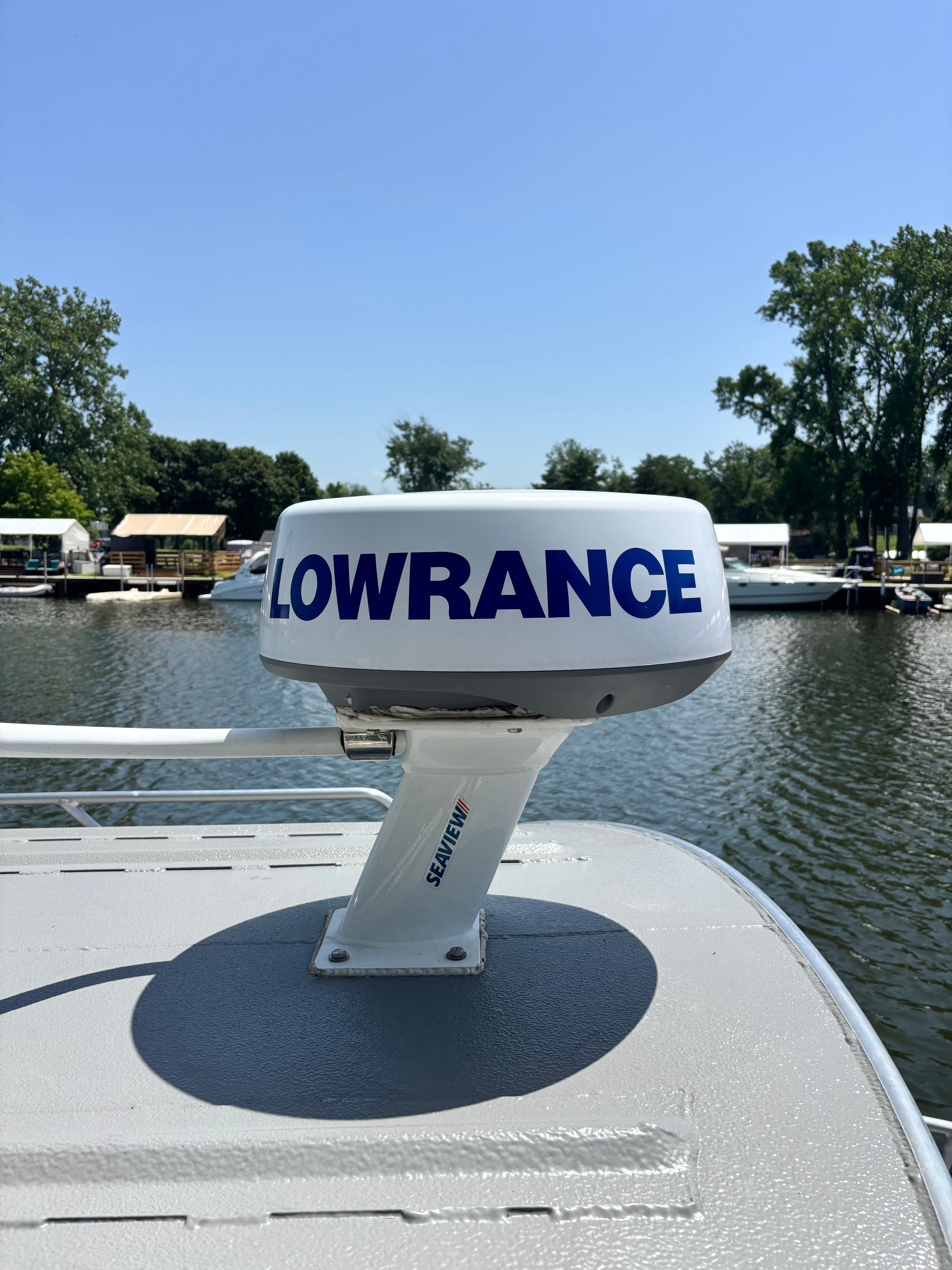 A Lowrance radar on a boat situated on calm water.