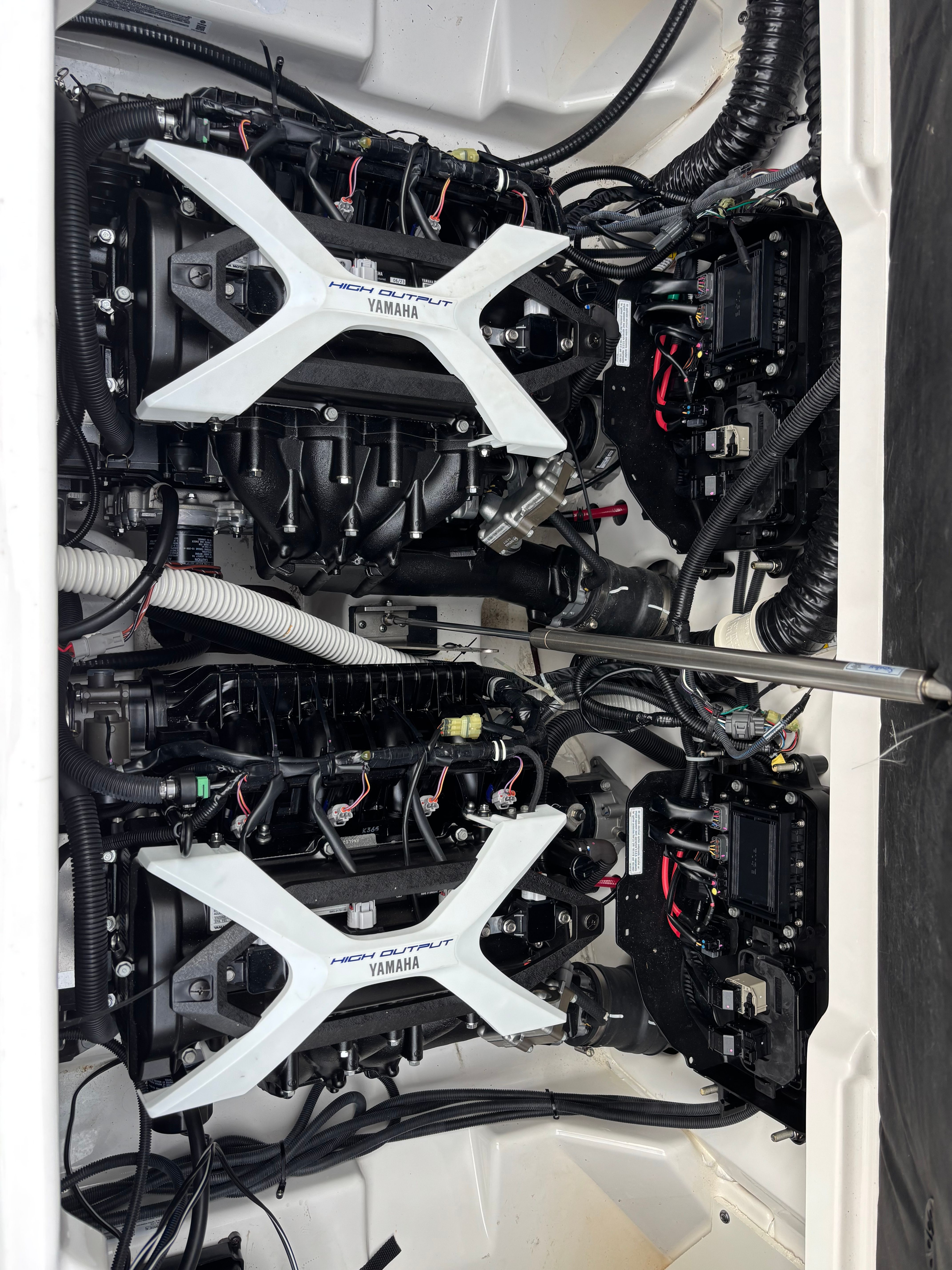 Two Yamaha engines inside a boat, connected with cables and hoses.