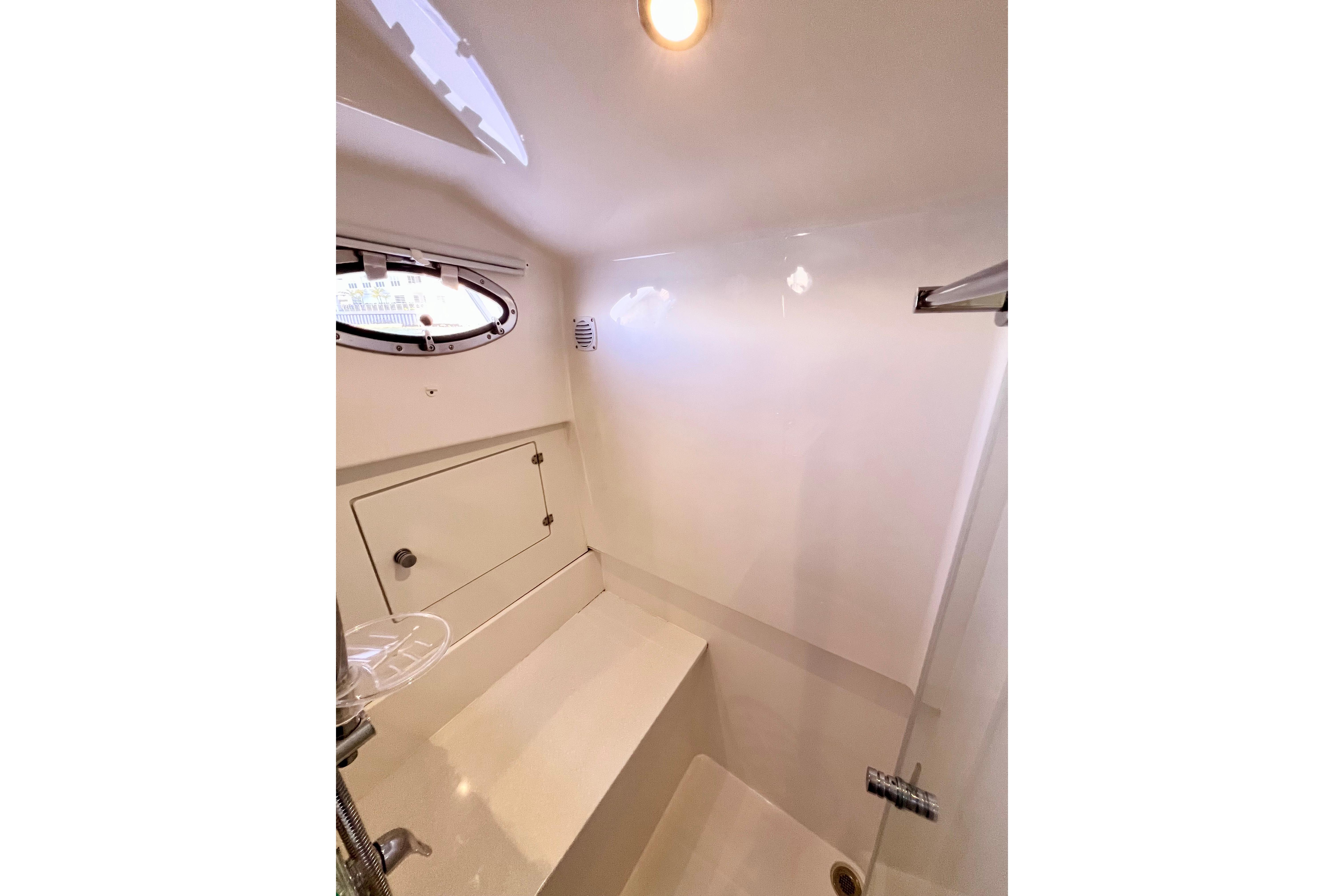 2021 Back Cove 390 yacht interior, featuring a compact, modern bathroom with a porthole window.