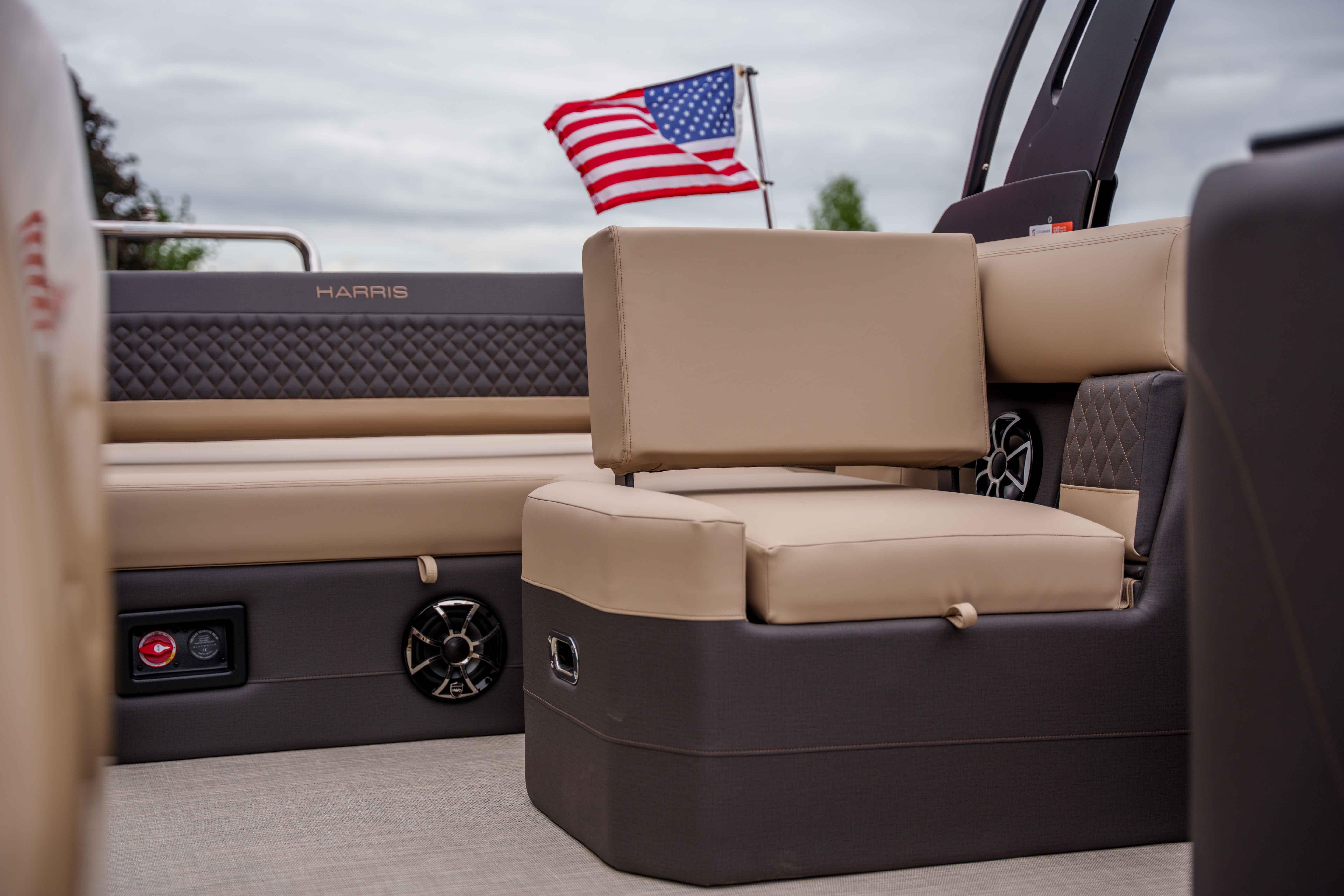 2026 Harris Sunliner 230 boat interior with beige seating and American flag in background.