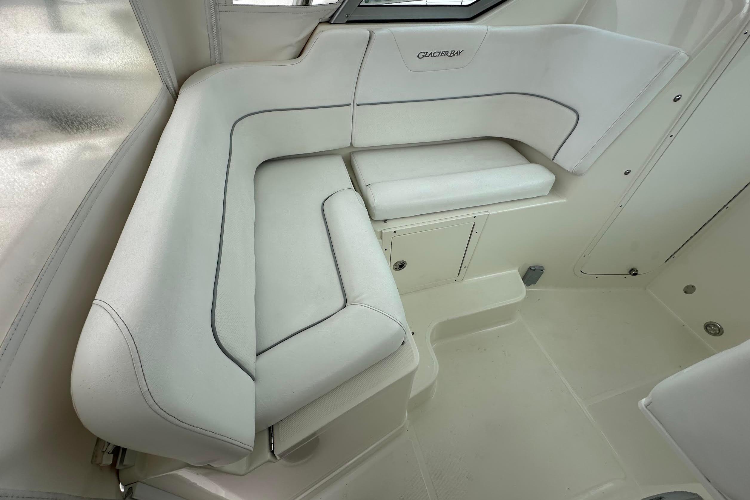 Interior seating of 2013 Glacier Bay 2680 Coastal Runner boat, featuring white cushioned seats.