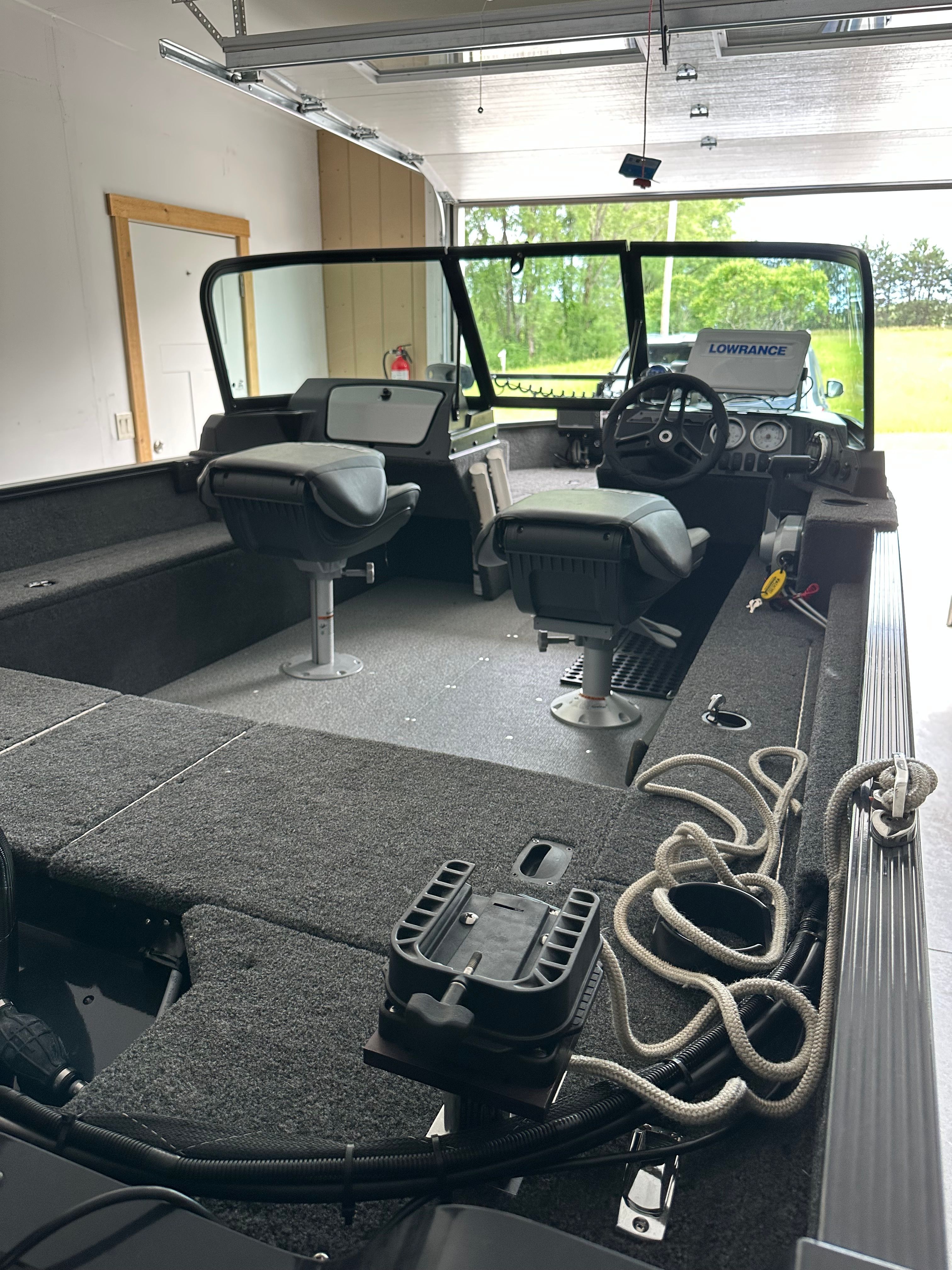 The image shows a 2025 Lund Pro Angler 1650 boat in a garage.