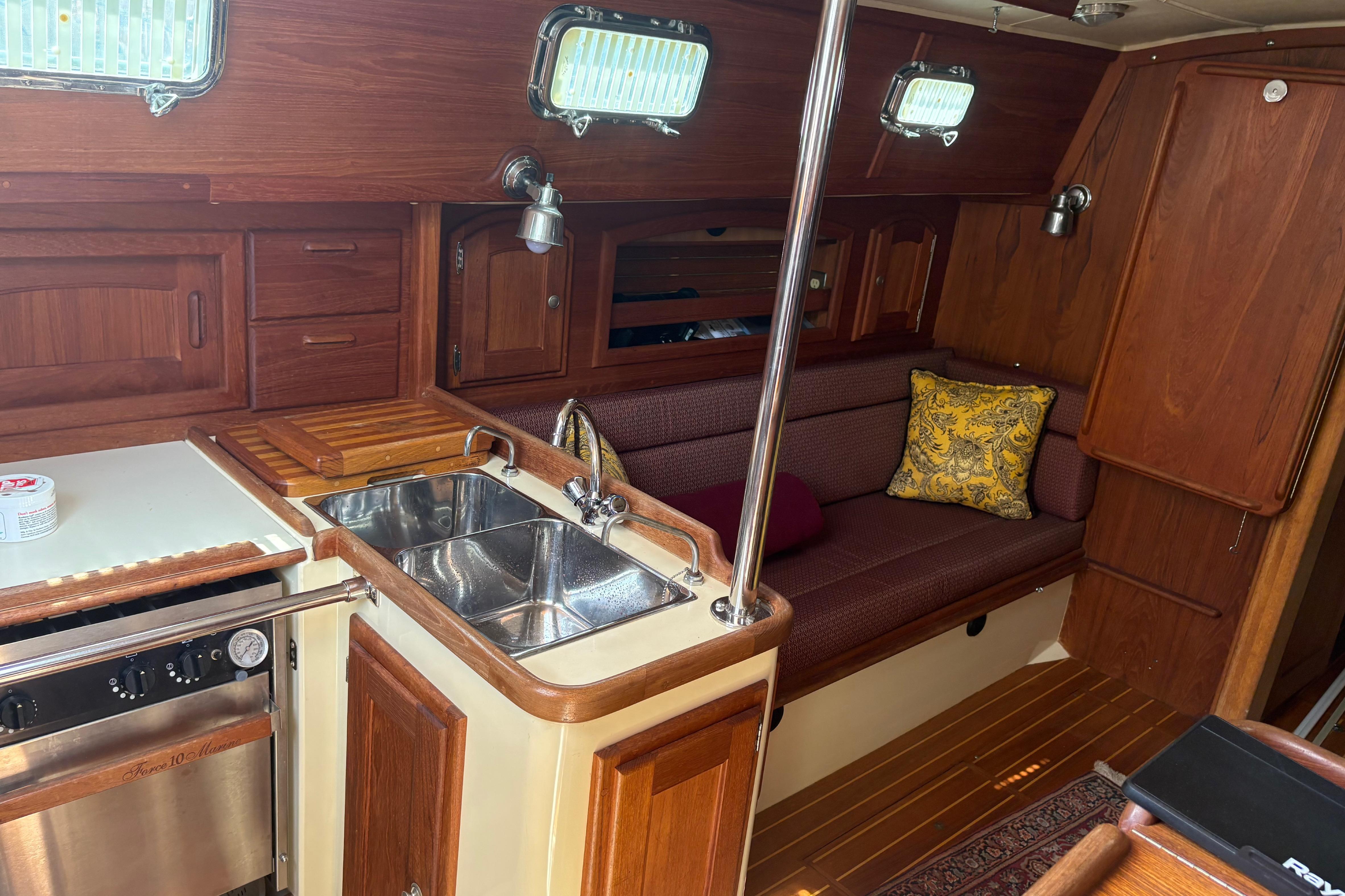 Interior of 1997 Pacific Seacraft Crealock 34 sailboat with wood cabinetry and cozy seating.