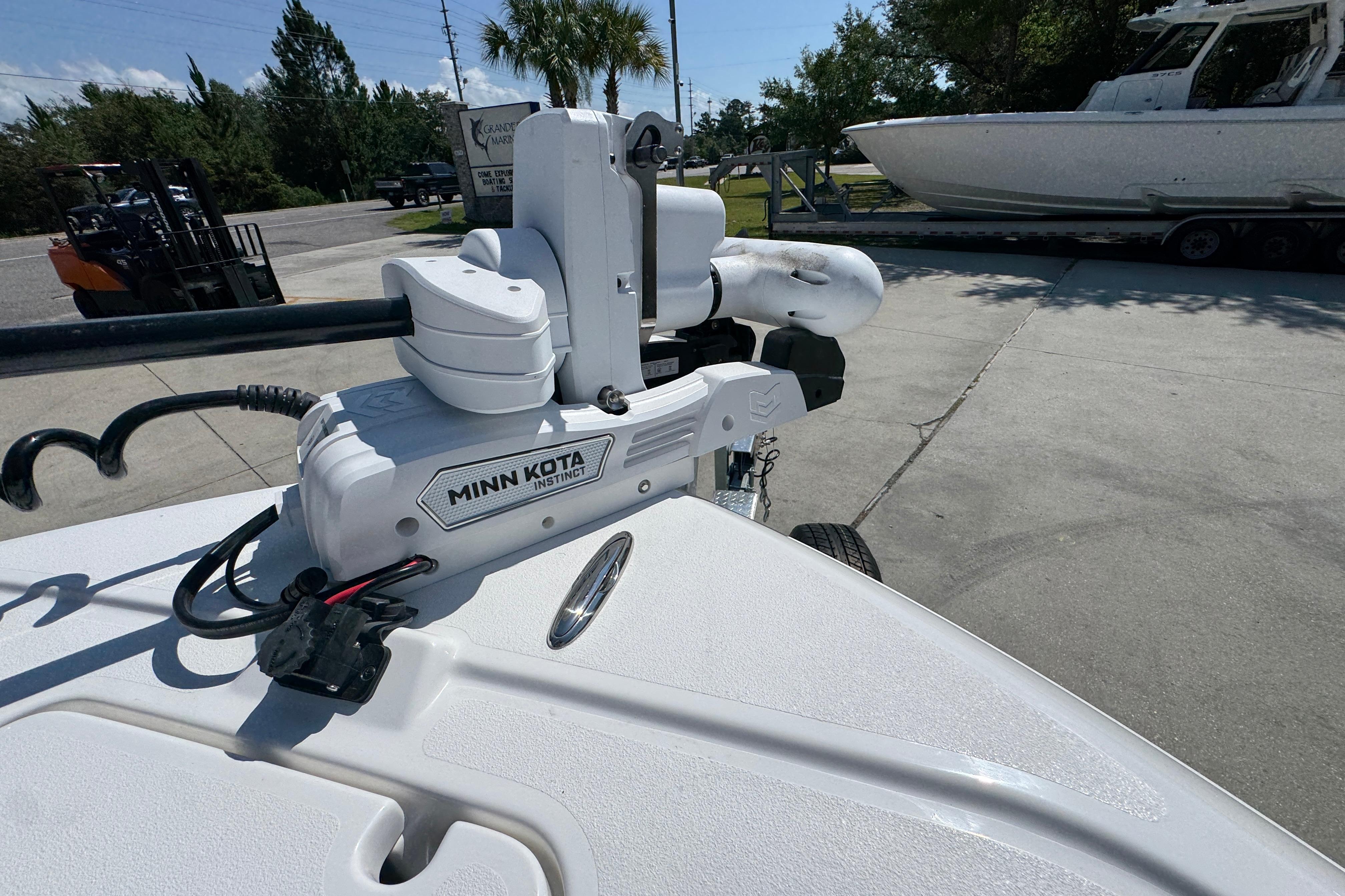 Minn Kota Instinct motor on 2027 Caymas 26 HB boat, parked outdoors.