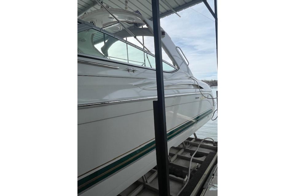 1999 Formula 400 Super Sport boat docked, showcasing sleek white exterior and green accents.