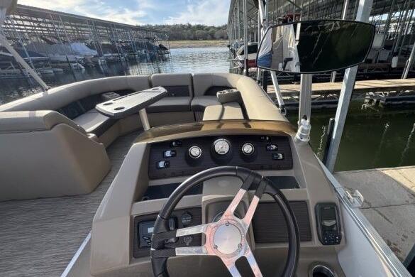 2021 Bennington L 24 Swingback boat interior with steering wheel and seating area.