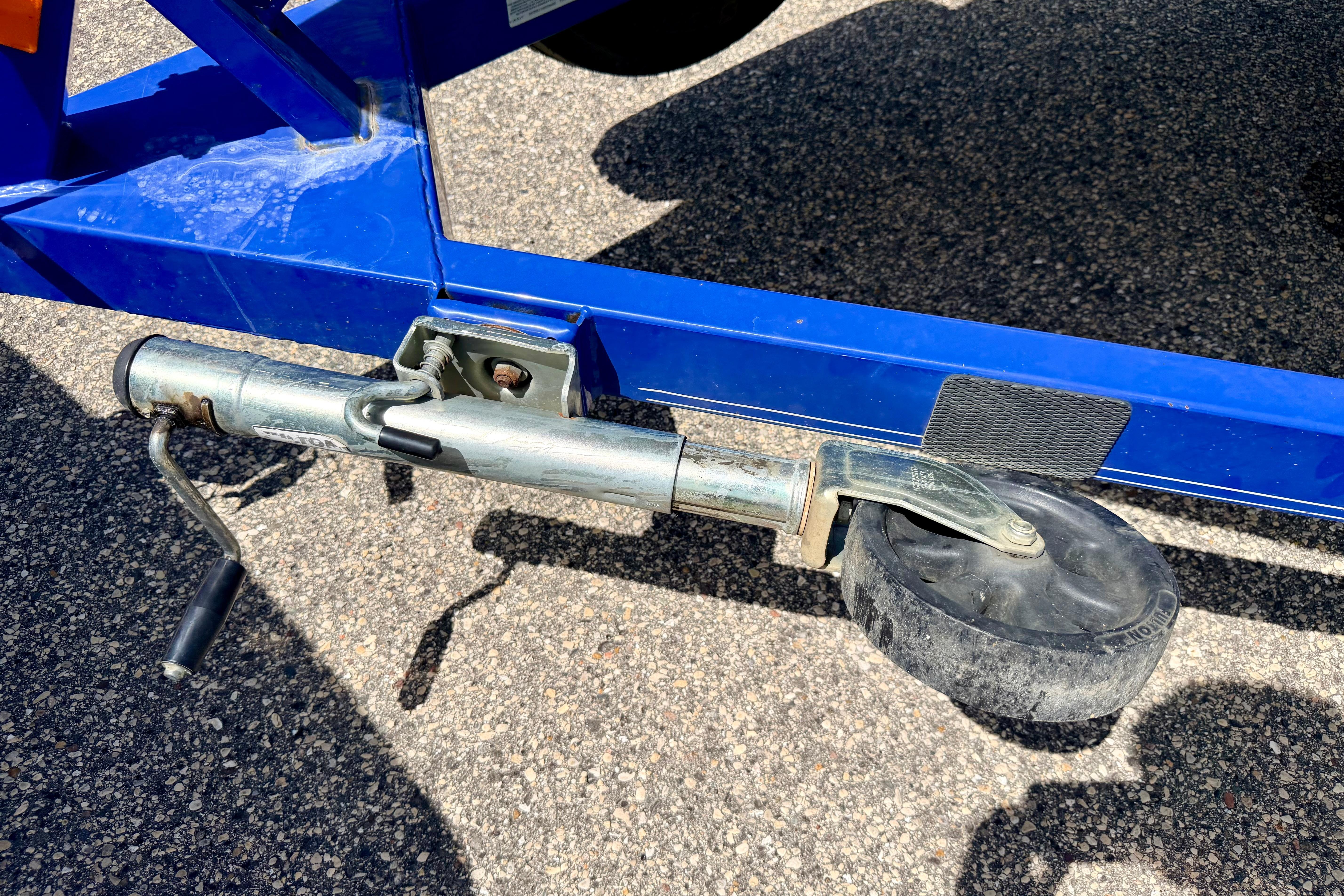 Trailer jack wheel on a 2008 Moomba Outback V boat trailer, parked on asphalt.