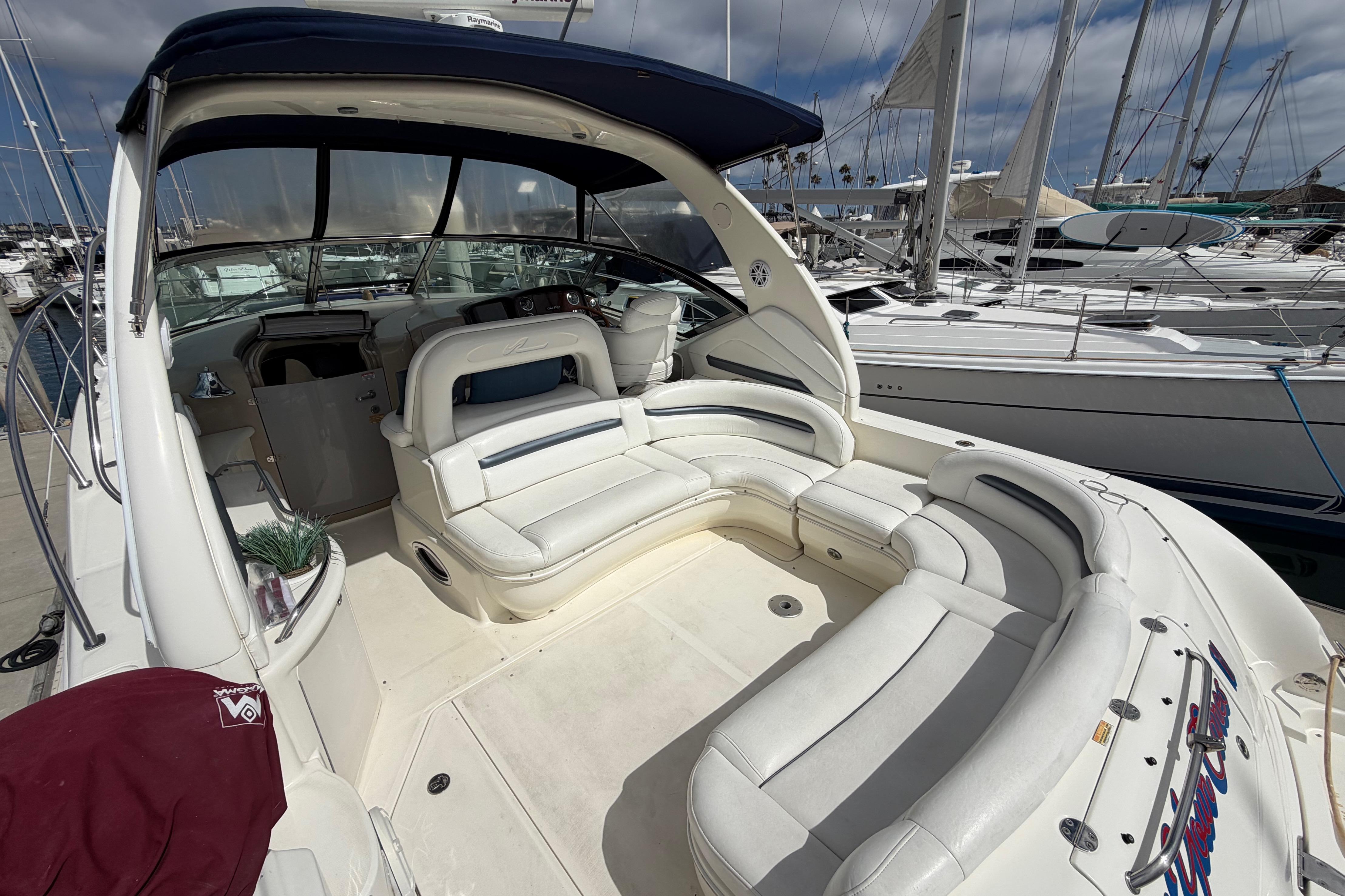 2003 Sea Ray 420 Sundancer yacht with spacious white seating and marina backdrop.