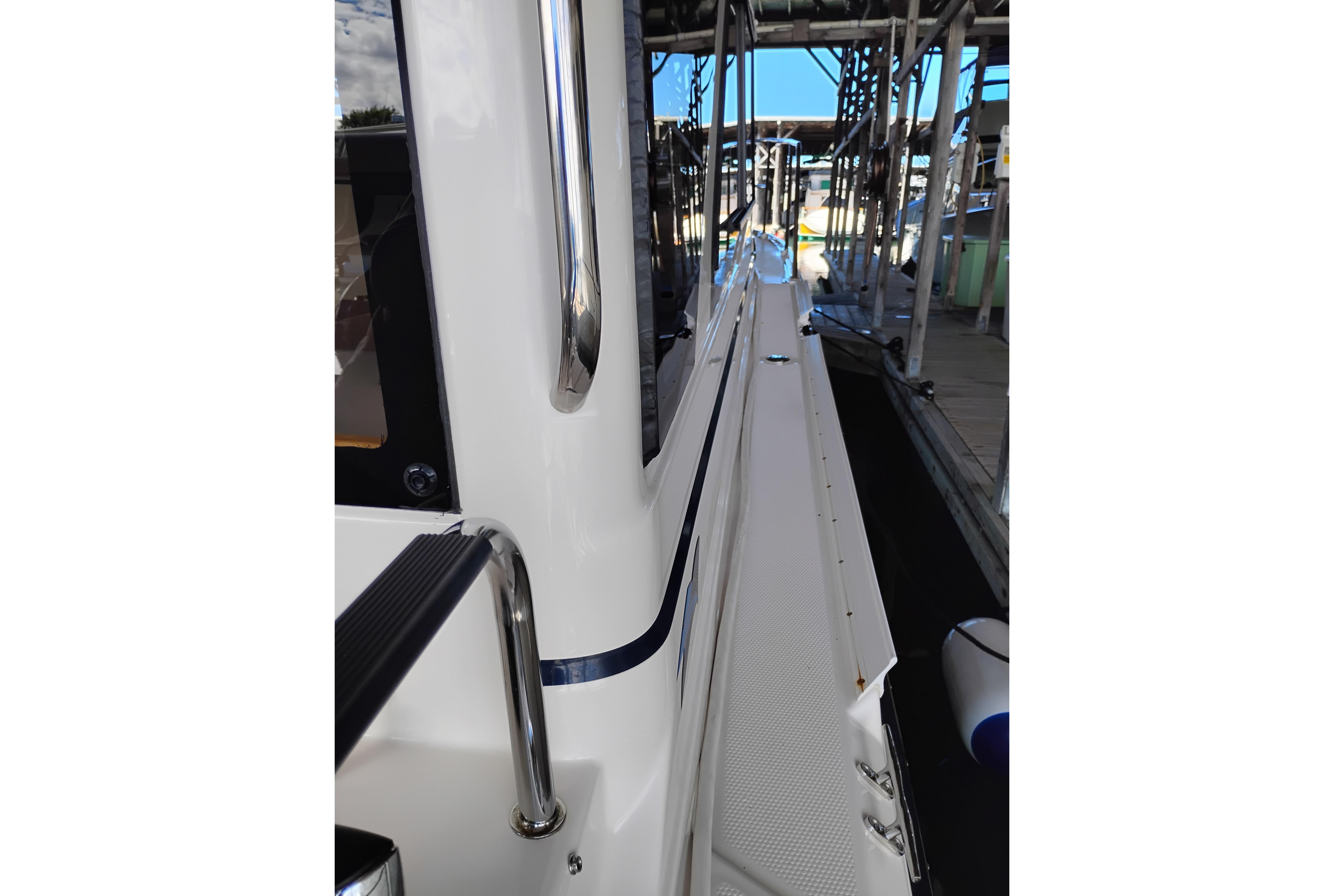 2022 Cutwater C-32 Coupe boat docked, showcasing sleek side design and stainless steel railings.