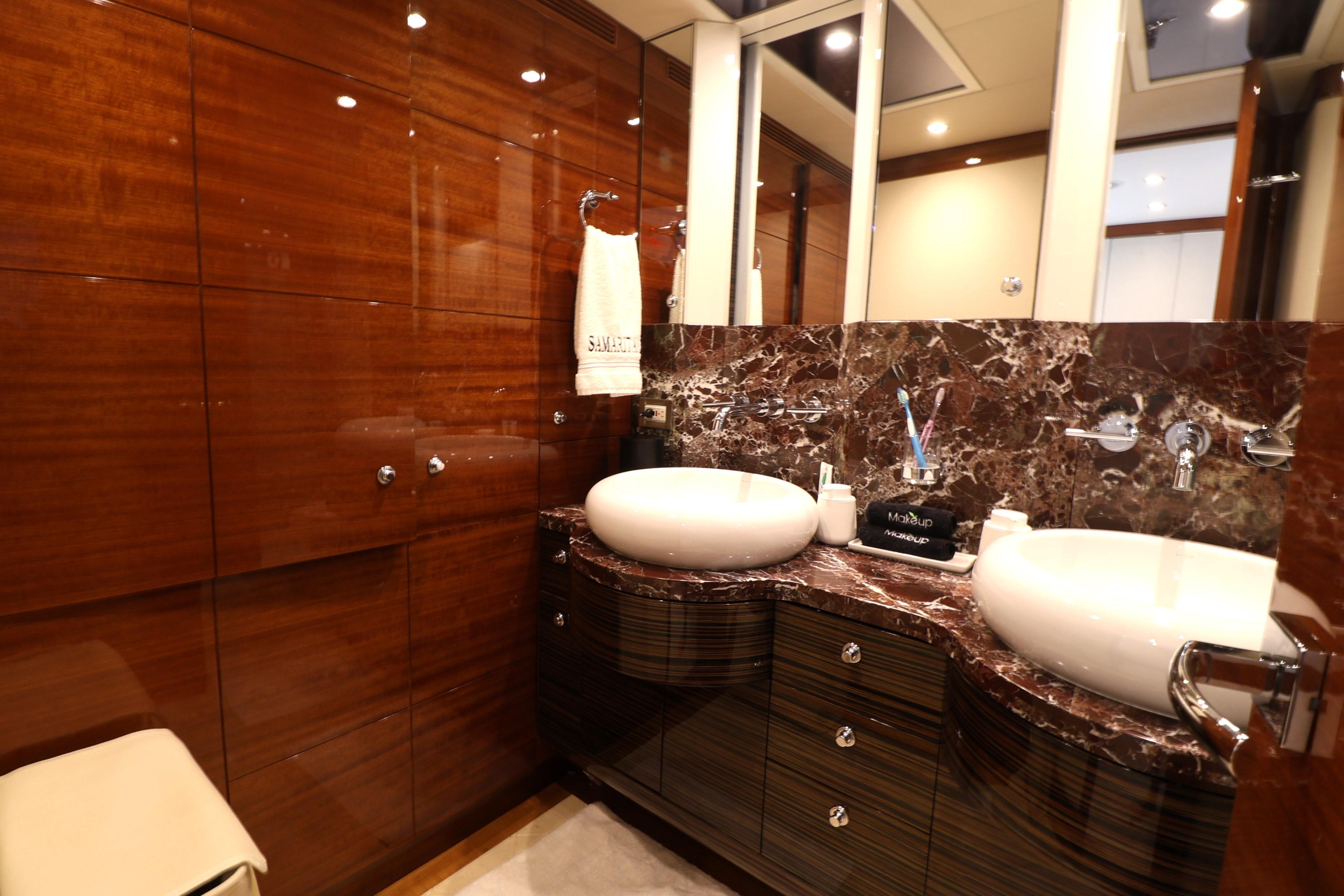 Luxurious bathroom in 2013 Cheoy Lee Bravo yacht with dual sinks and elegant wood paneling.