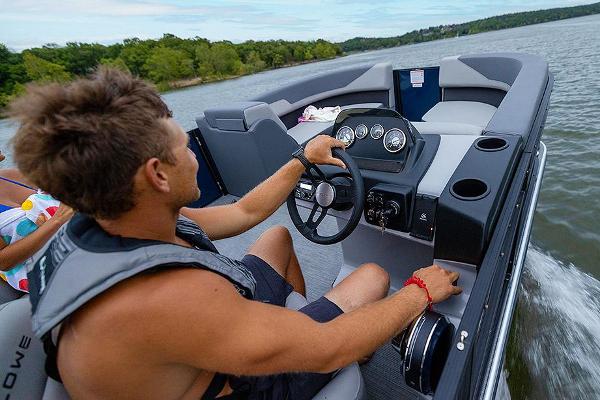Manufacturer Provided Image: Man steering 2025 Lowe LS 190 boat on a scenic lake.