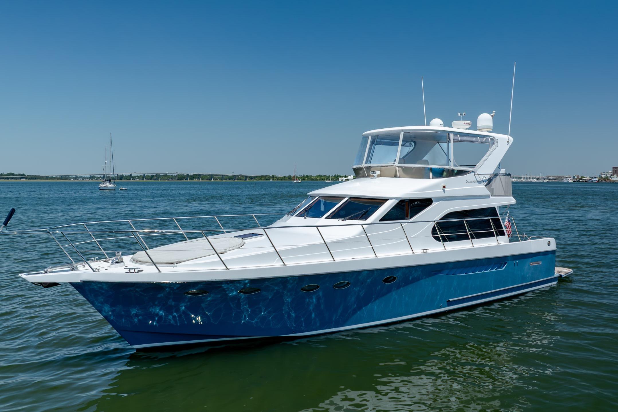 Luxury Ocean Alexander yacht cruising on a sunny day in calm waters.
