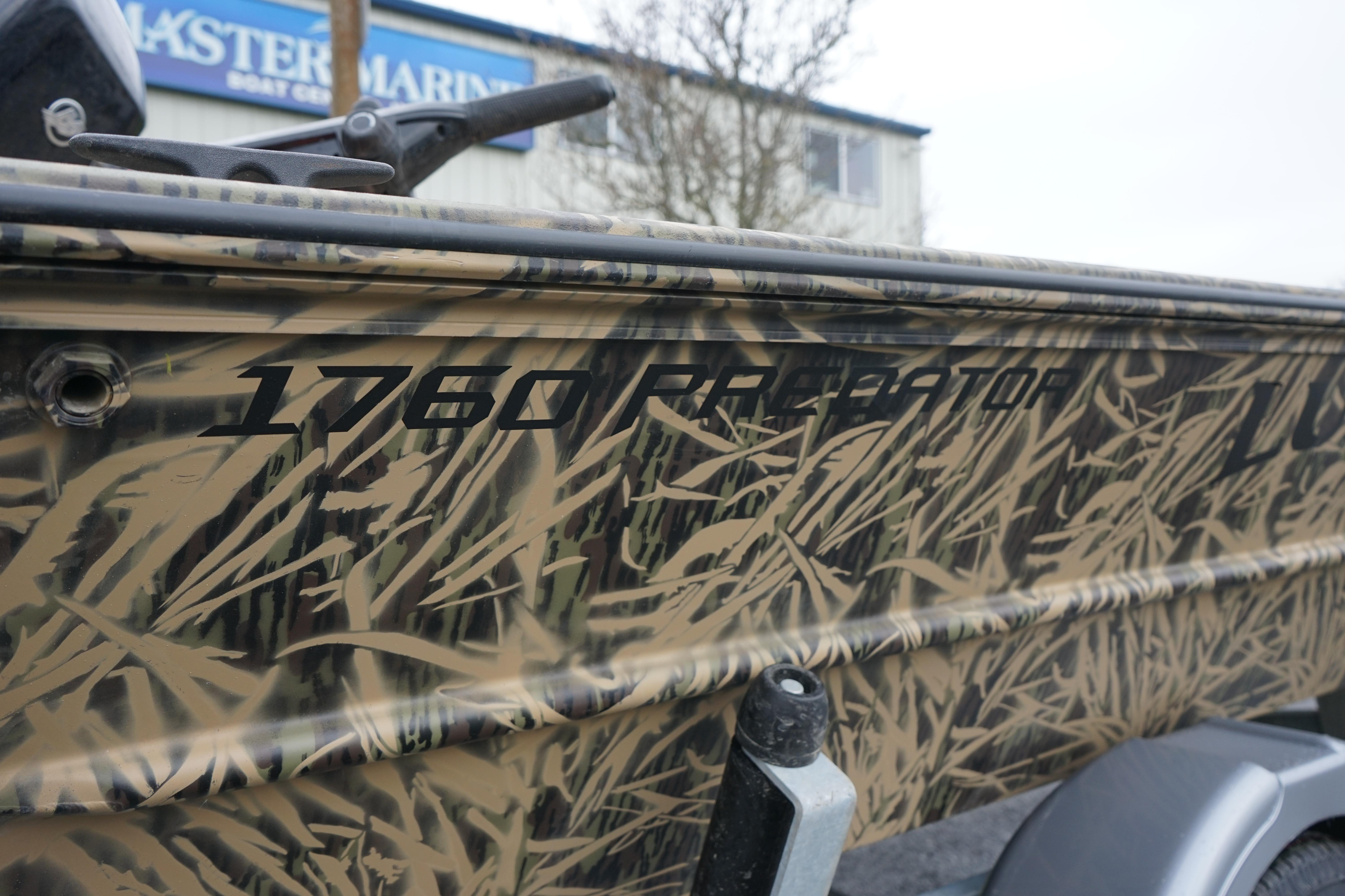 2024 Lund 1760 Predator Tiller boat with camouflage design, side view.