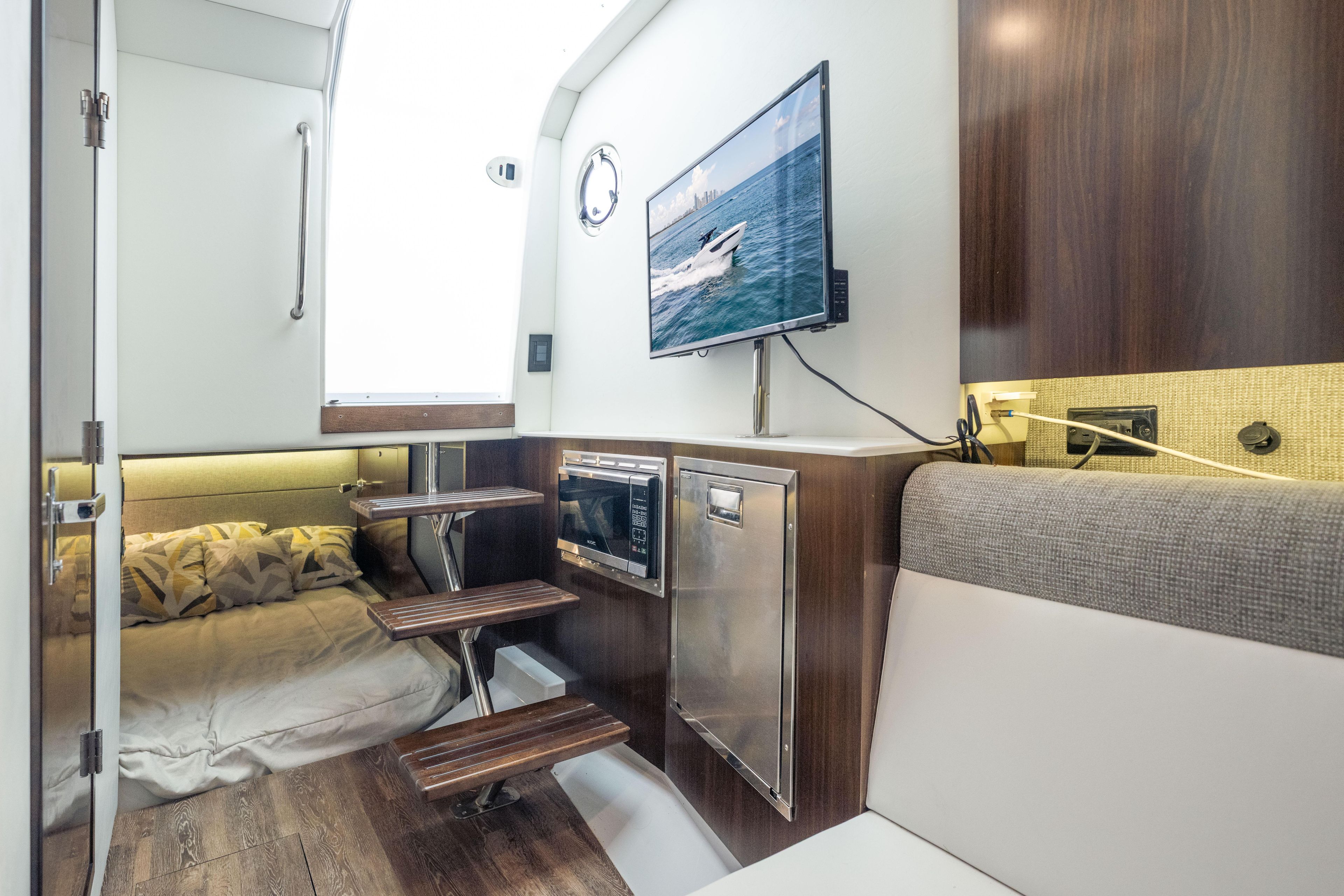 Interior of 2021 Cruisers Yachts 38 GLS with cozy bed, TV, and modern amenities.