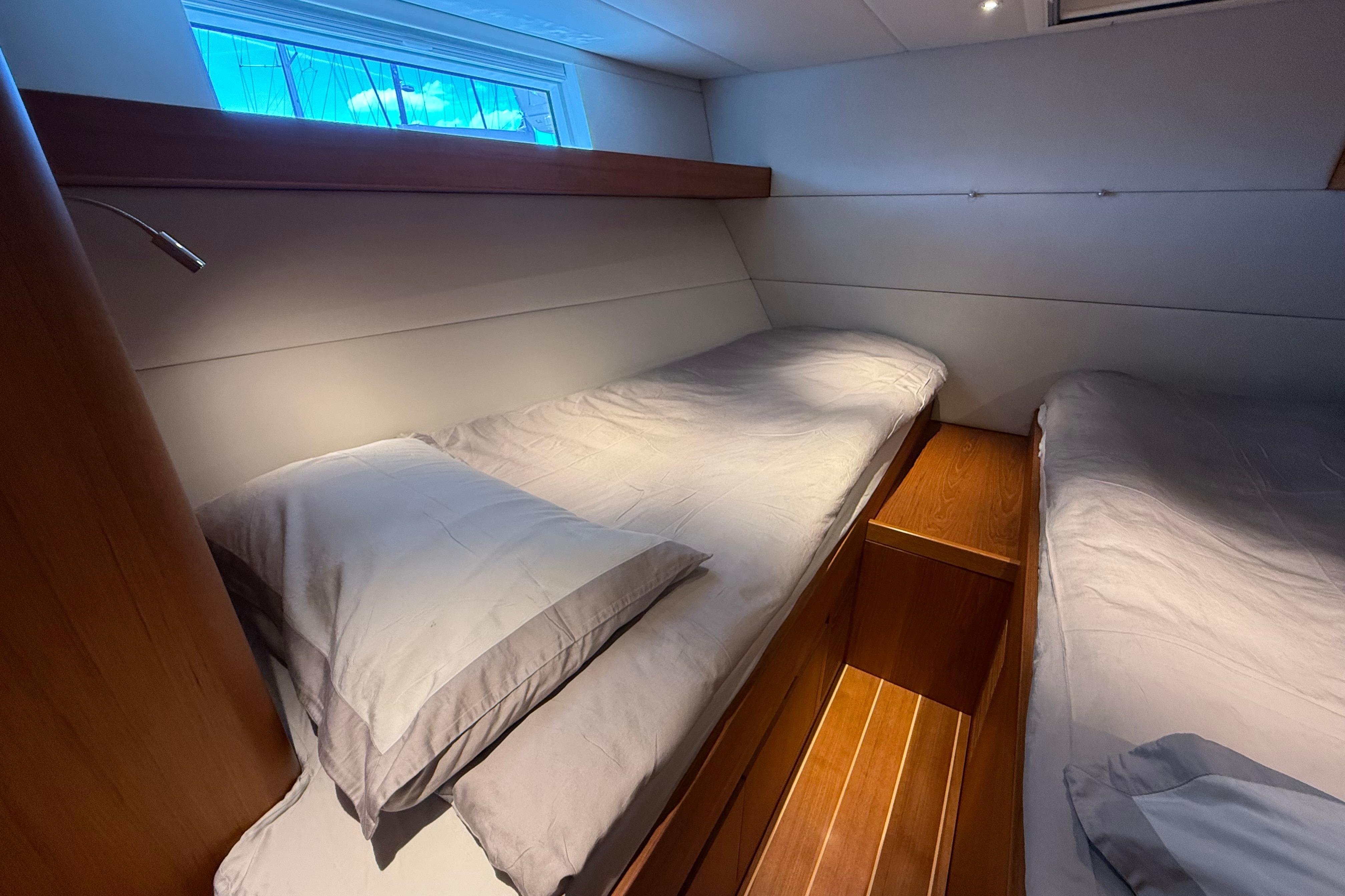 Interior of 2018 Contest 67CS yacht with twin beds and wooden flooring.