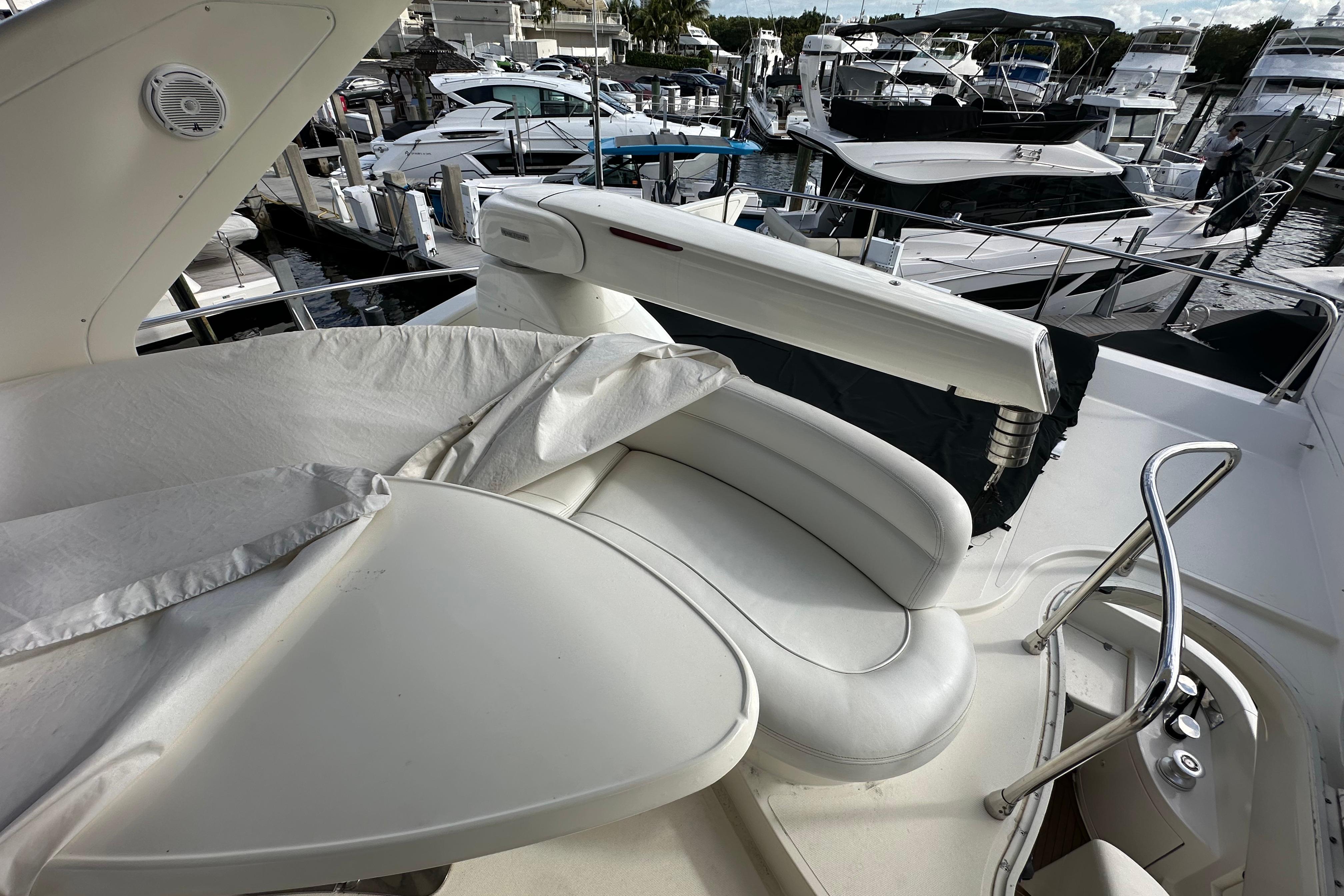 2004 Azimut 55E yacht deck with white seating and marina view.