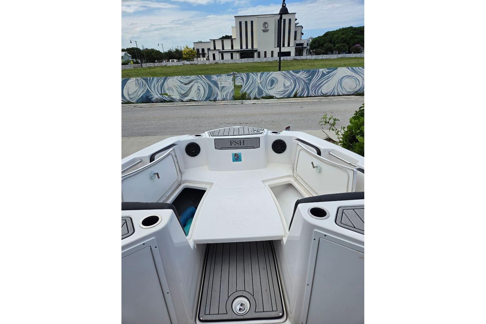 2024 Yamaha Boats 222 FSH Sport E interior with seating and storage compartments.