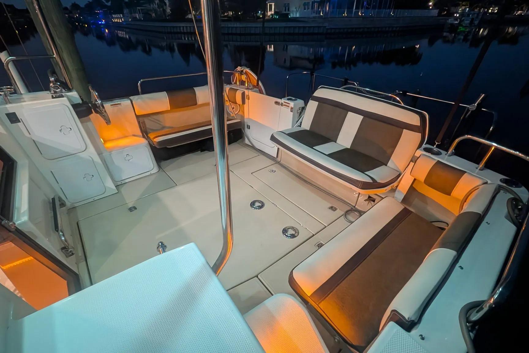 2015 Ranger Tugs R-29 S boat interior with cushioned seating and ambient lighting at night.