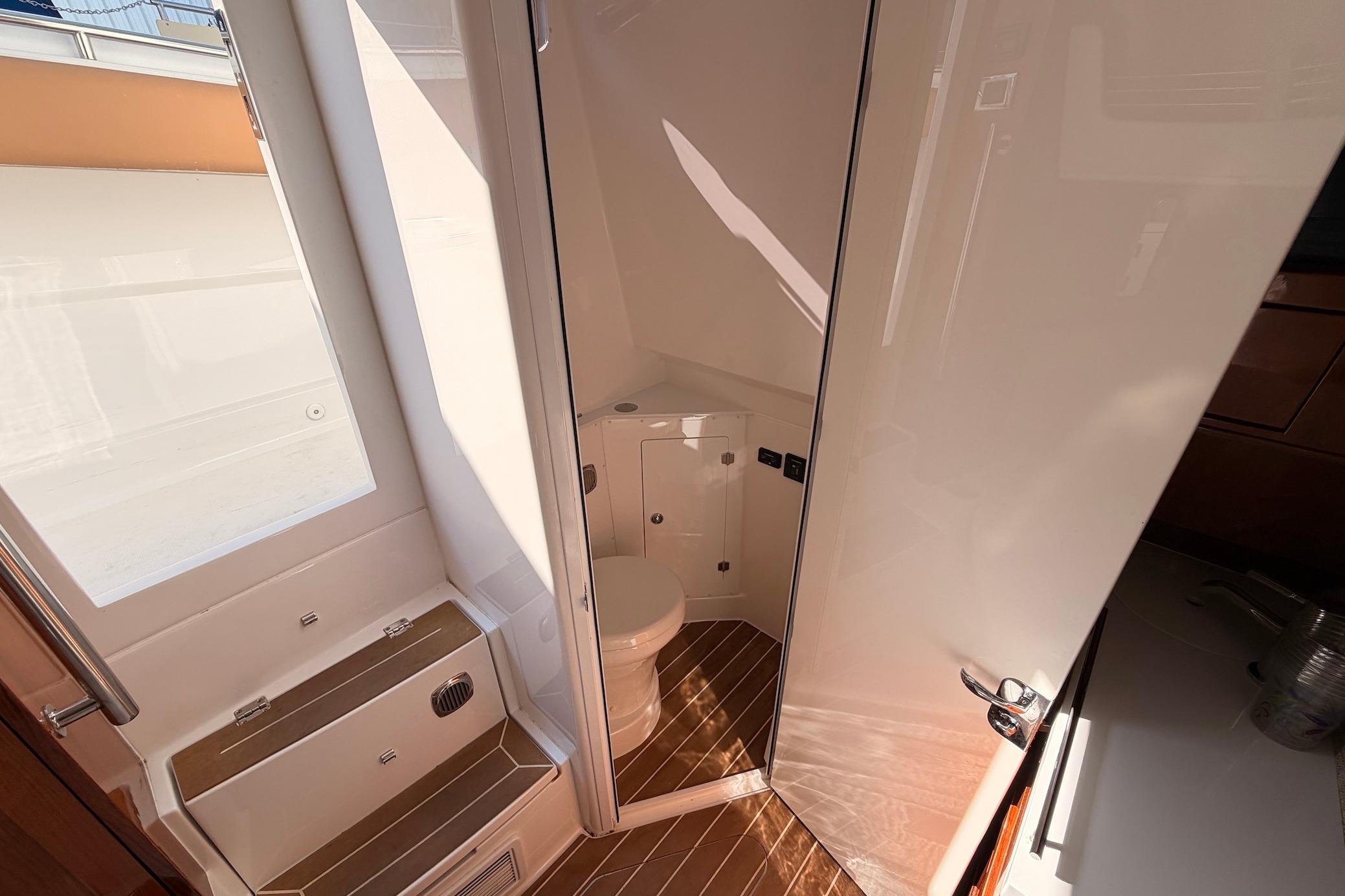 Interior of 2022 HCB 42 Lujo boat featuring a compact, modern bathroom design.