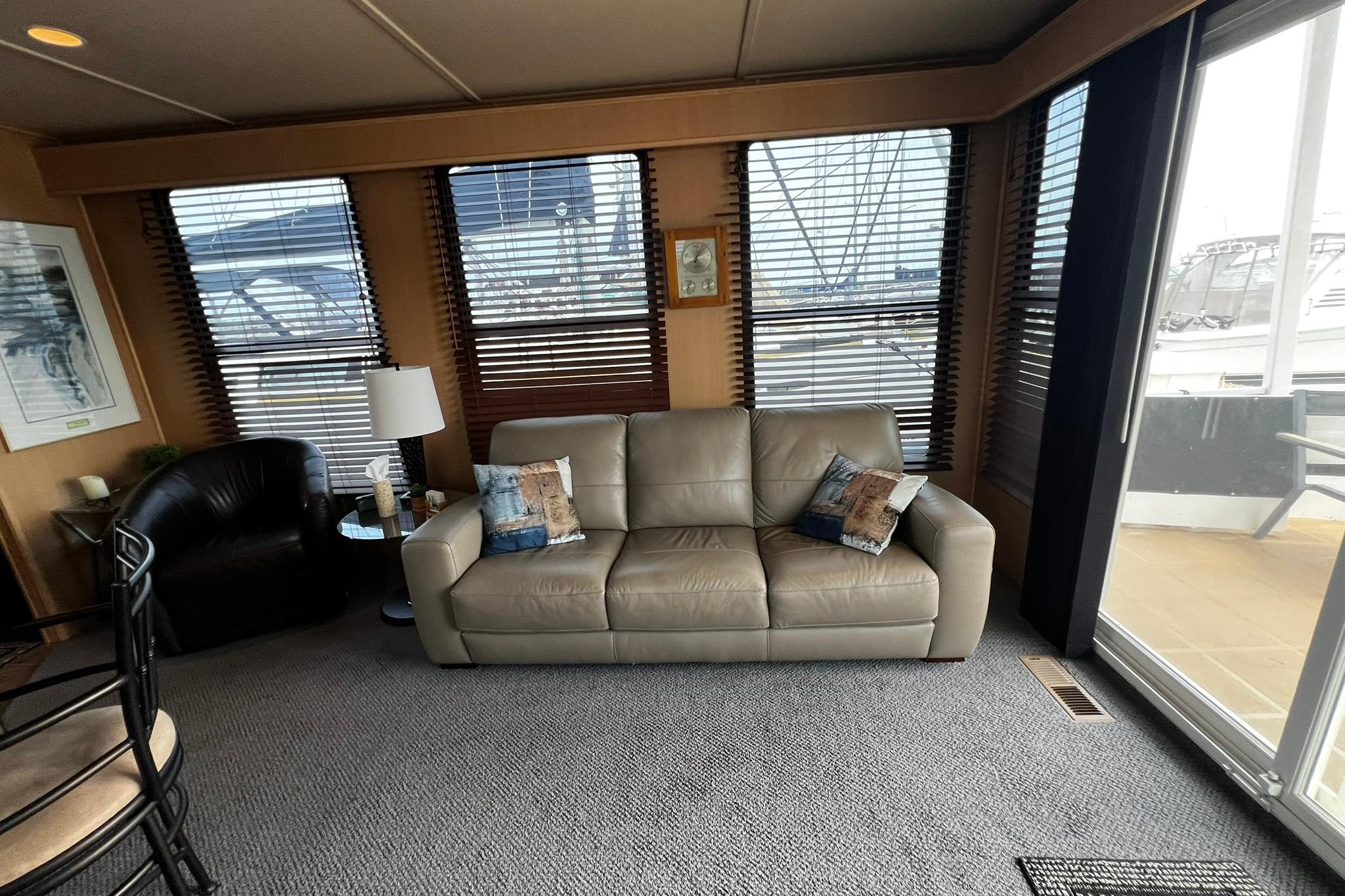 Luxurious Skipperliner 480 Flybridge 2010 interior with leather sofa and marina view.