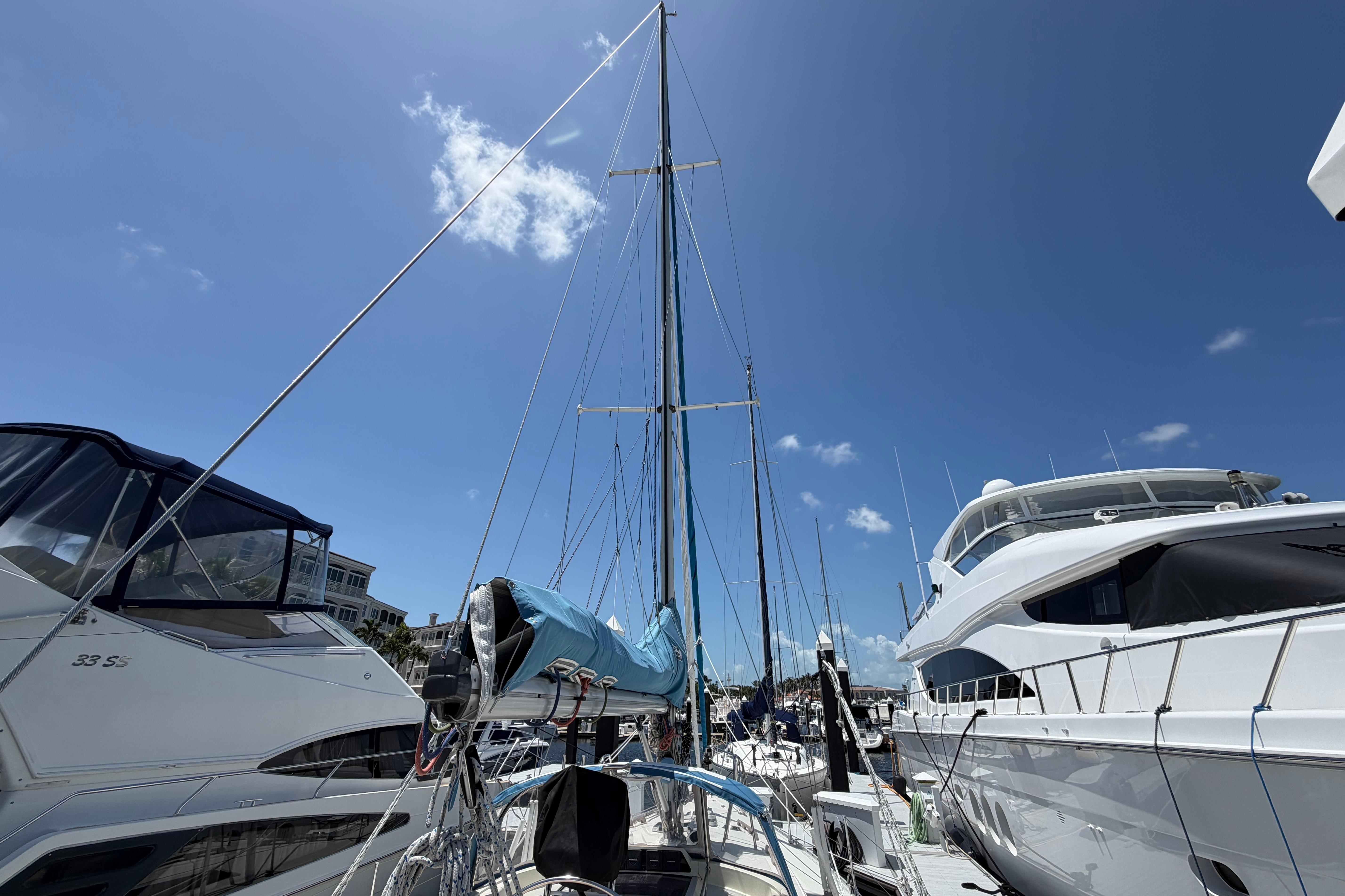 Sailboats docked at marina under clear blue sky, featuring 1987 Moody 376 yacht.