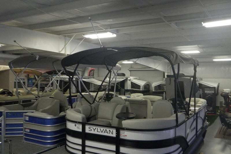 2027 Sylvan Mirage 820 CLZ DH pontoon boat displayed indoors with canopy and seating.